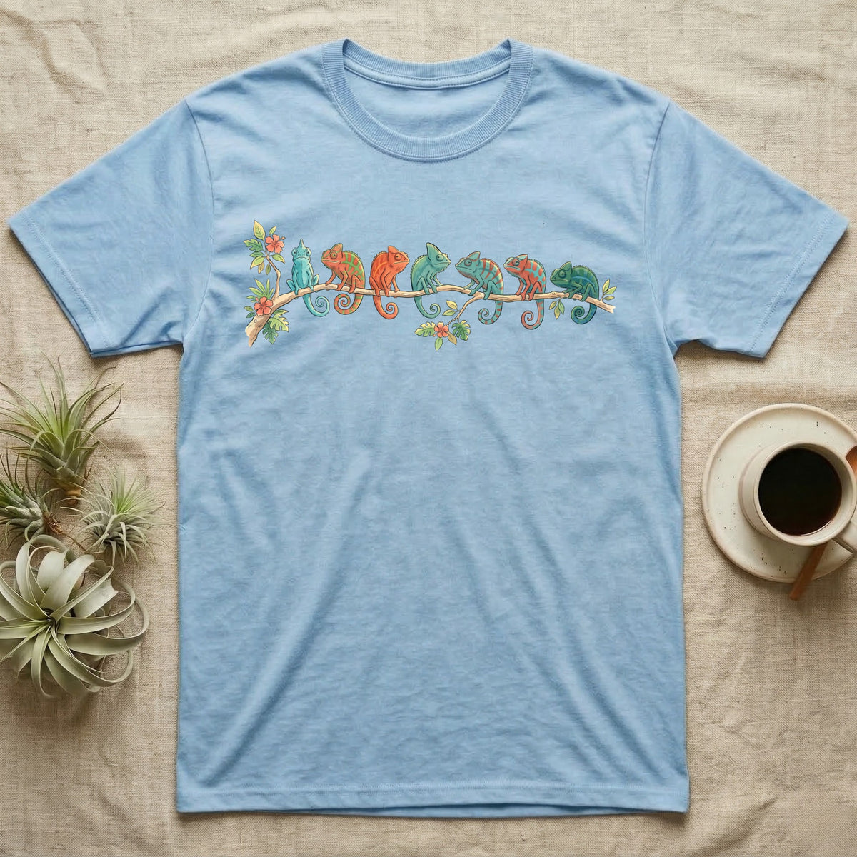 Panther Chameleon Canopy Crew T-Shirt in Light Blue — Watercolor illustration of seven panther chameleons in Madagascar locale colours on a branch, dark grey T-shirt design.