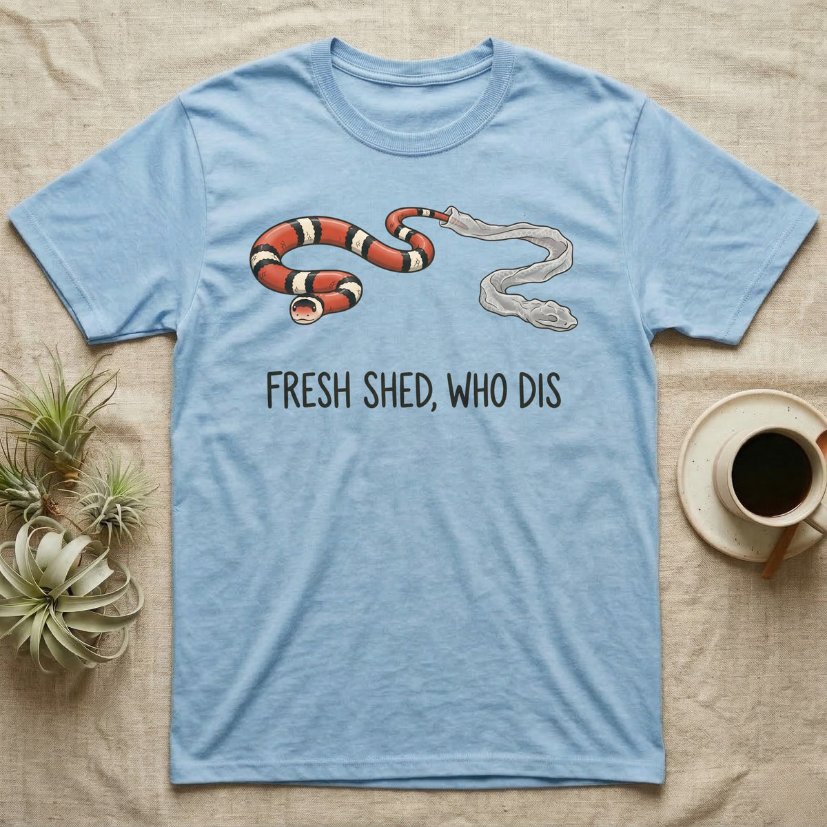 Milk Snake Shed T-Shirt in Light Blue — Glossy red, black and white milk snake with its tail still in its translucent shed skin above the words FRESH SHED, WHO DIS