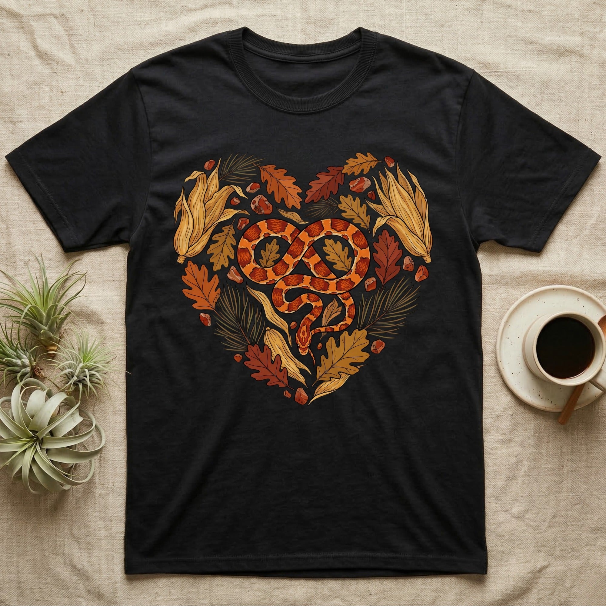 Black t-shirt with a heart design of fall leaves, acorns, and a snake.