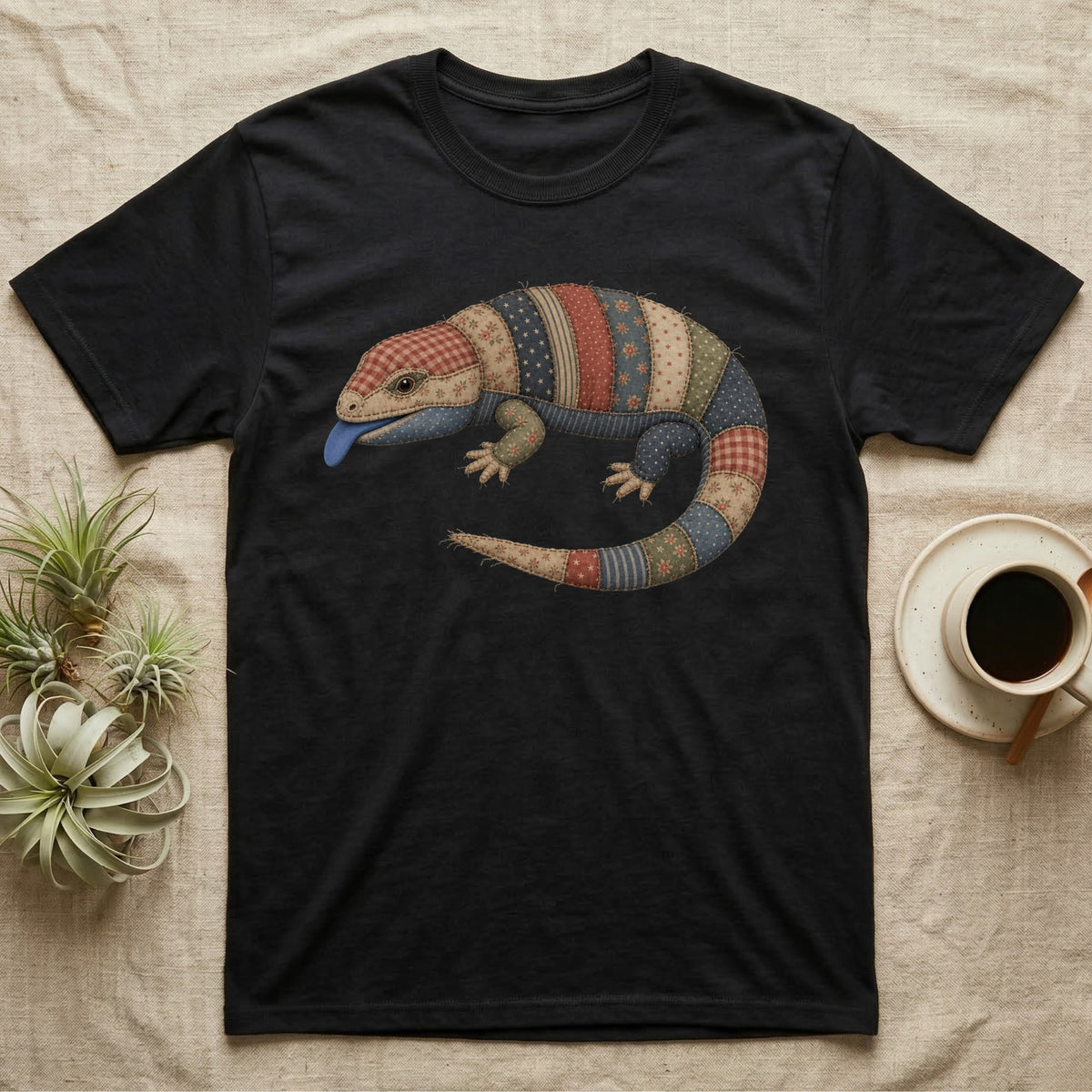 Black t-shirt with a patchwork lizard and blue tongue design.