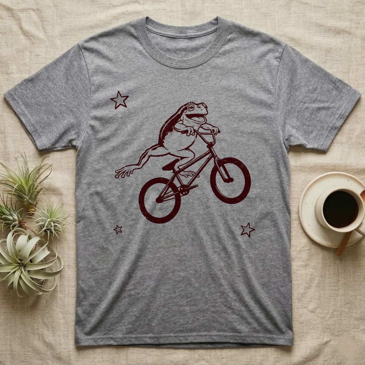 Tree Frog Can-Can T-Shirt in Sport Grey — Distressed one-ink oxblood screenprint of a White's tree frog airborne on a BMX bike, both back legs kicked off the pedals and swung to one side, hands still on the bars.