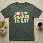 99% Snakes Keeper T-Shirt in Military Green — Distressed-block wordmark reading 99 percent snakes 1 percent cat with a small pie-chart accent glyph.