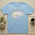 Light blue t-shirt with "Bad Skin Day" and gecko graphic.