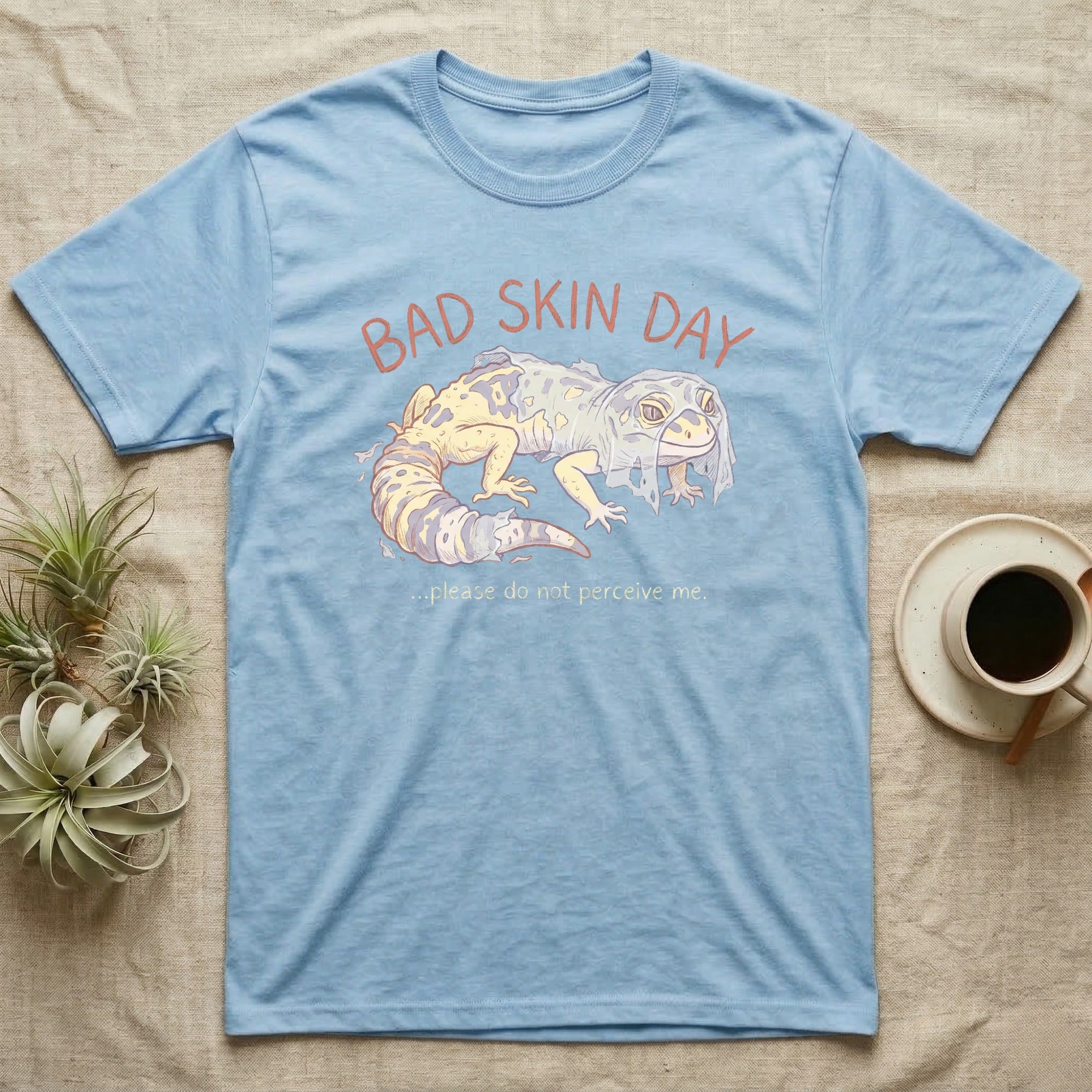 Light blue t-shirt with "Bad Skin Day" and gecko graphic.