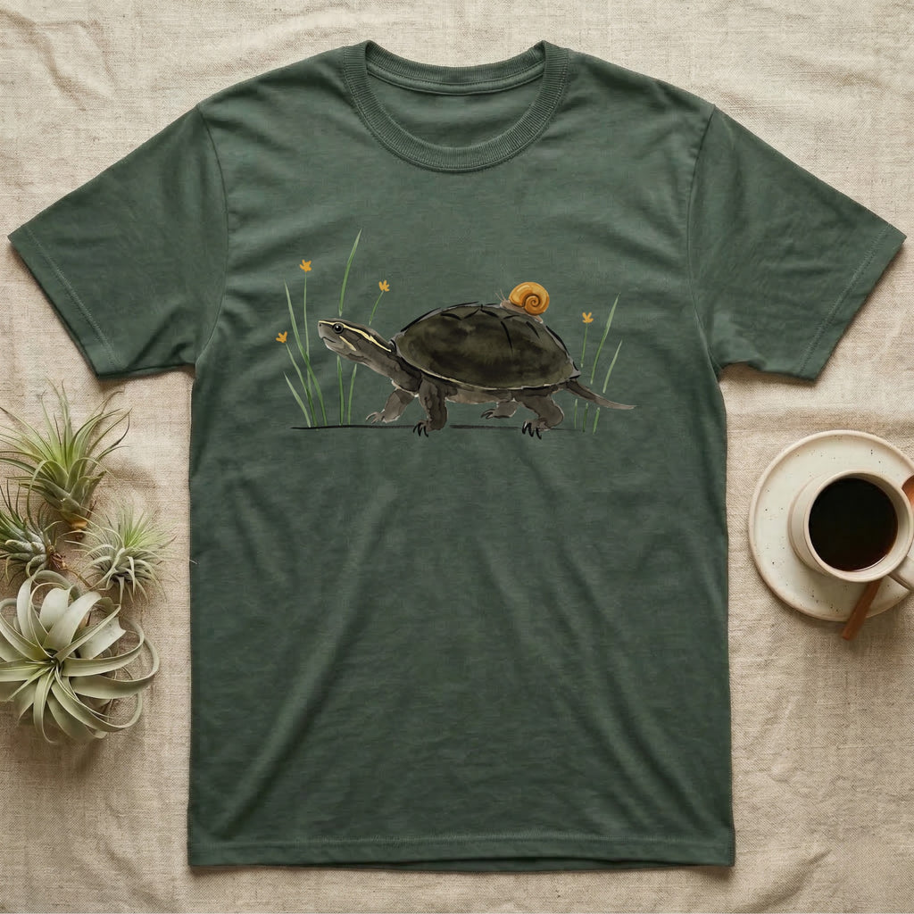Musk Turtle Hitchhiker T-Shirt in Military Green — Watercolour musk turtle walking left with a ramshorn snail on its shell, beside slender grass blades with tiny amber flowers.