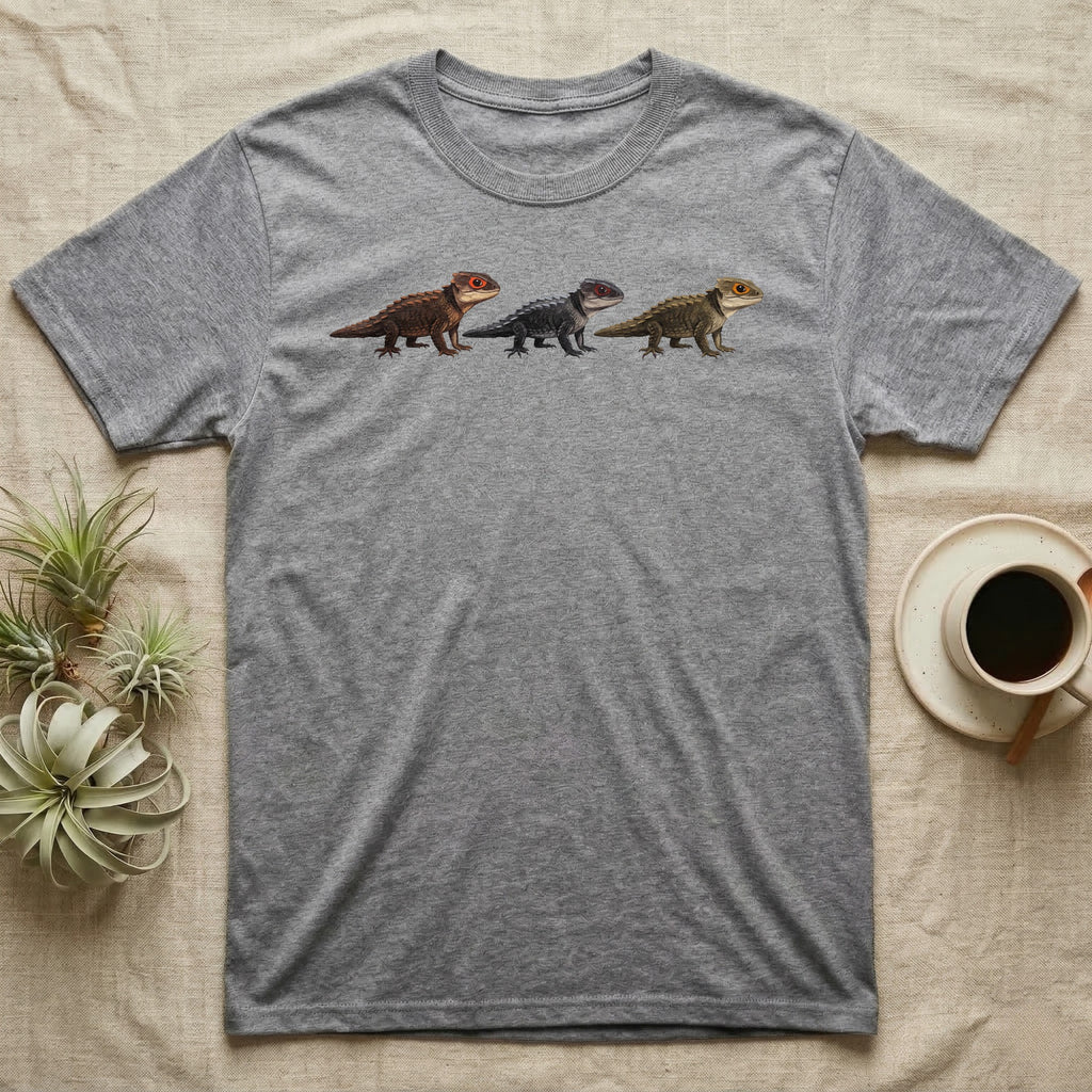 Crocodile Skink Morph Triptych T-Shirt in Sport Grey — Three red-eyed crocodile skinks in a row, painted in thick impasto — bronze, near-black and pale olive forms.