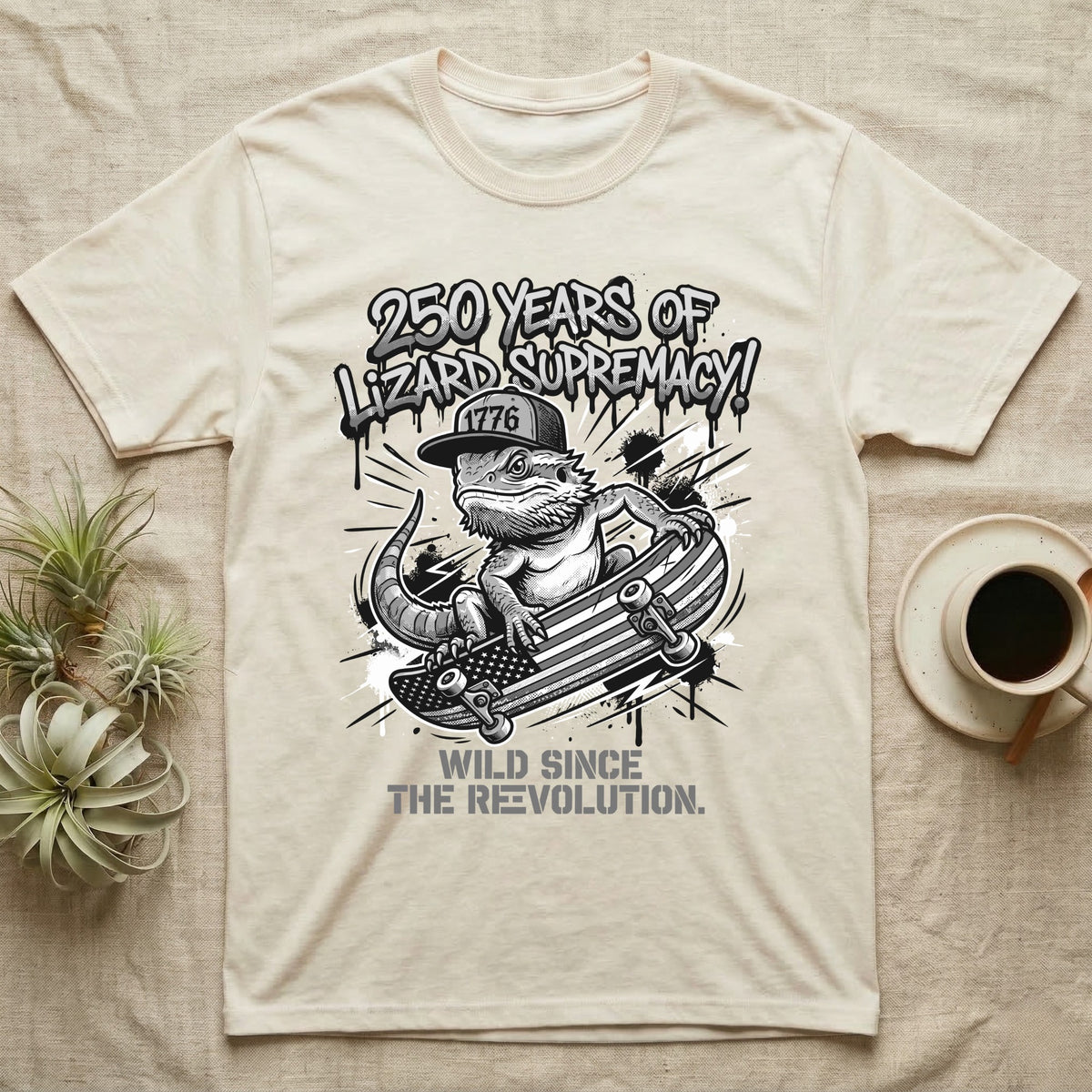 Bearded Dragon Skater T-Shirt in Natural — Black-and-white bearded dragon in a 1776 snapback on a flag skateboard under text 250 Years of Lizard Supremacy.