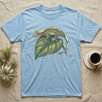 Light blue t-shirt with a crested gecko on a green leaf.