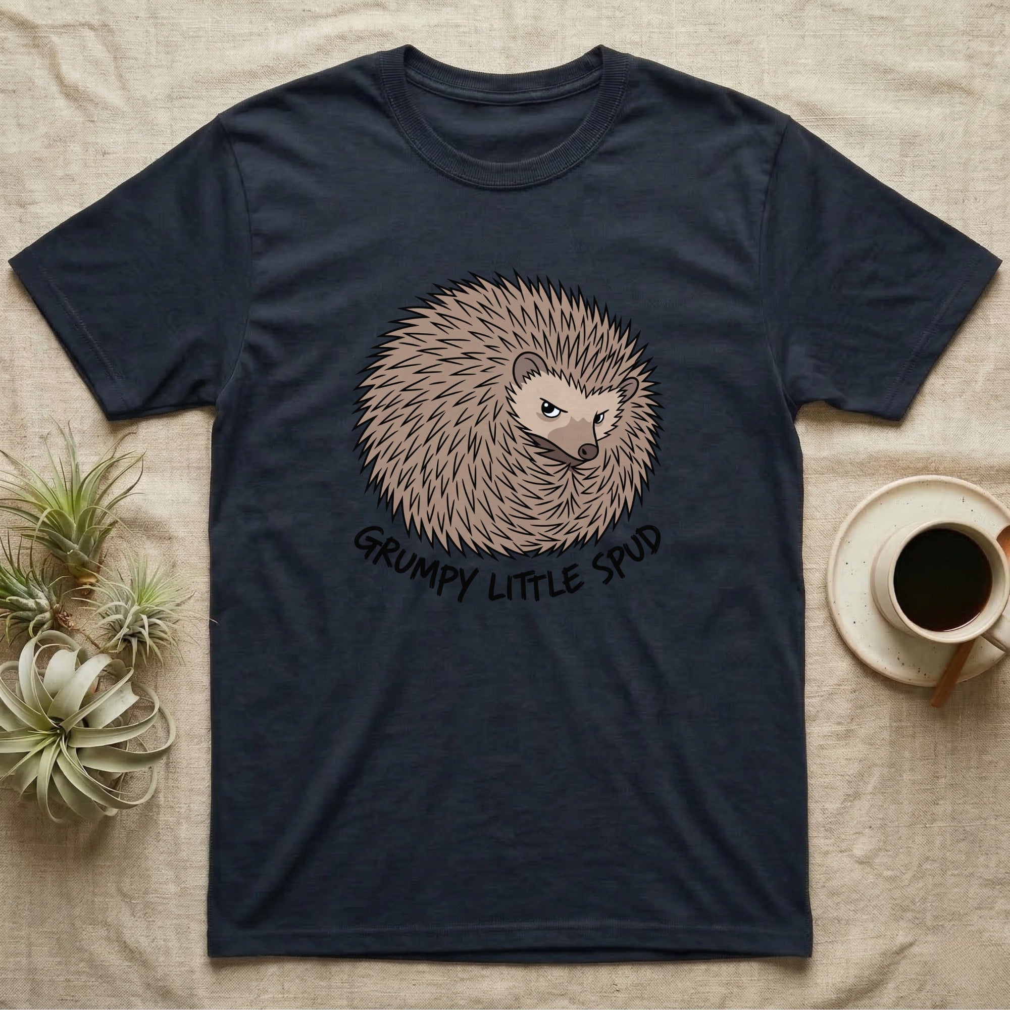 Dark t-shirt with a grumpy hedgehog graphic and text "GRUMPY LITTLE SPUD".
