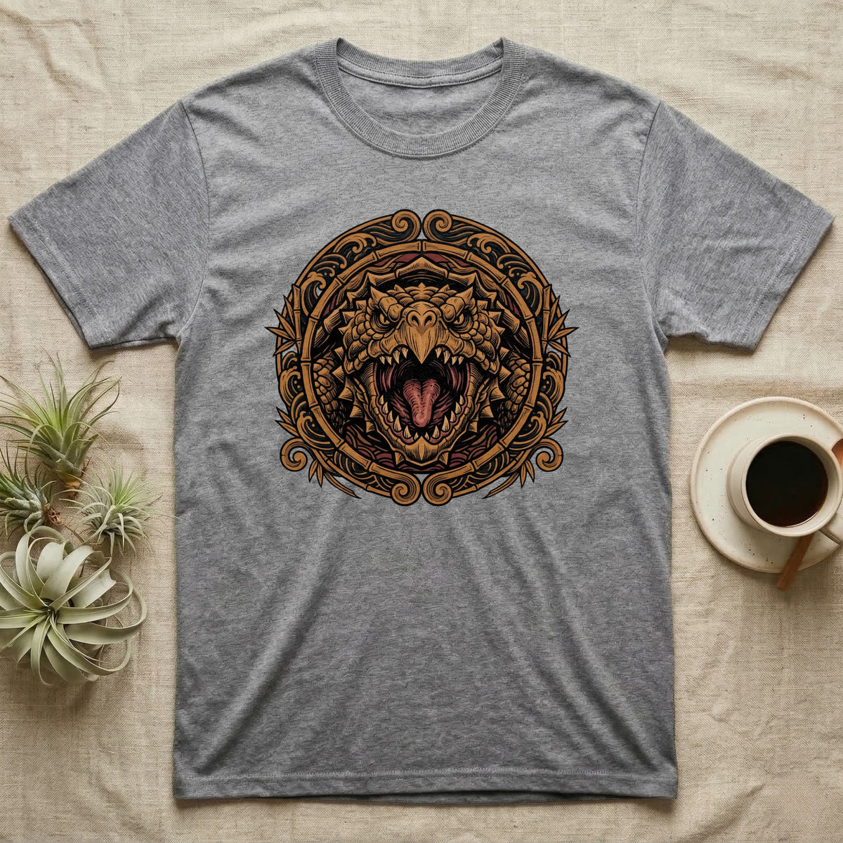 Grey t-shirt with a circular, ornate dragon head design in gold.