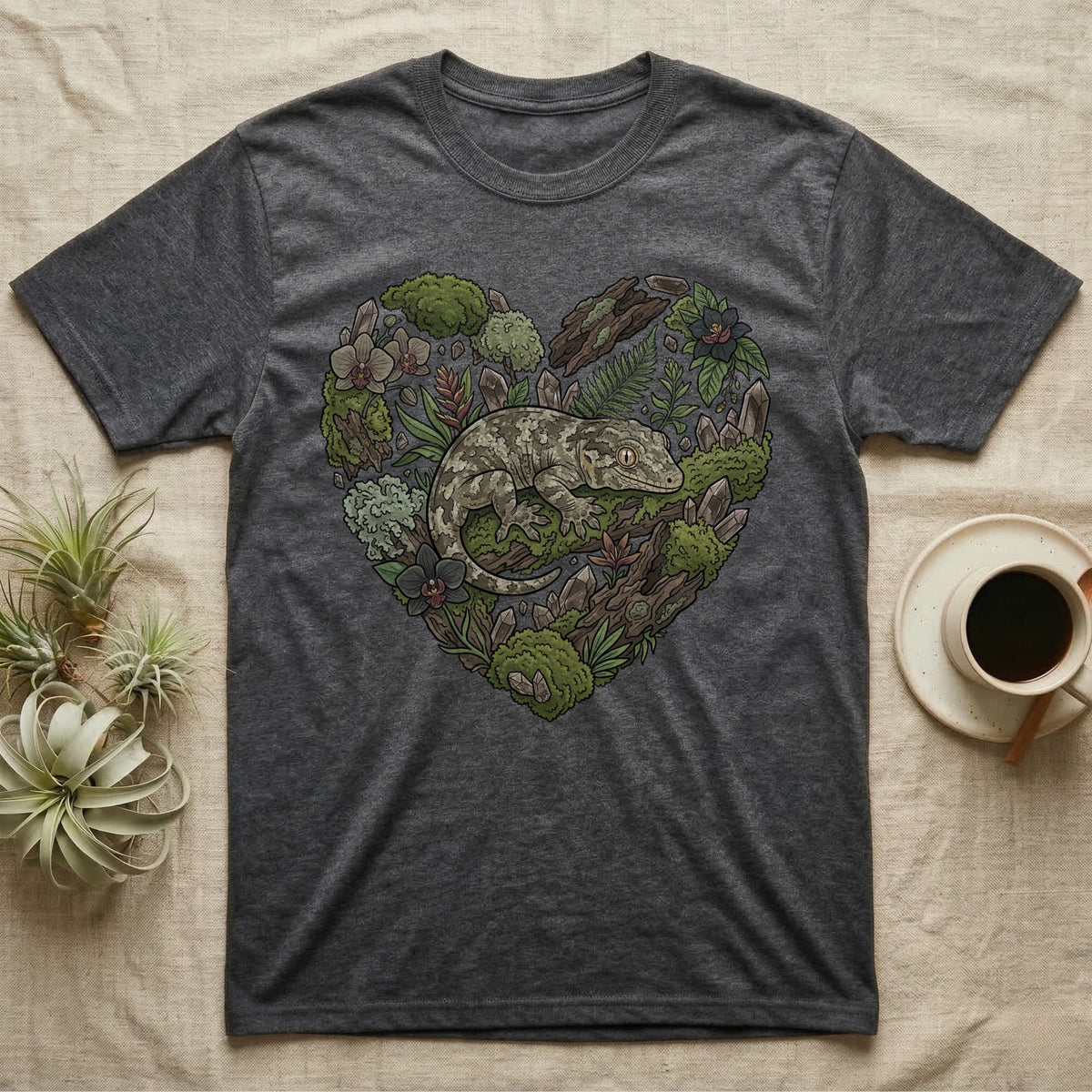 Dark grey t-shirt with a heart-shaped design featuring a gecko and mossy forest elements.