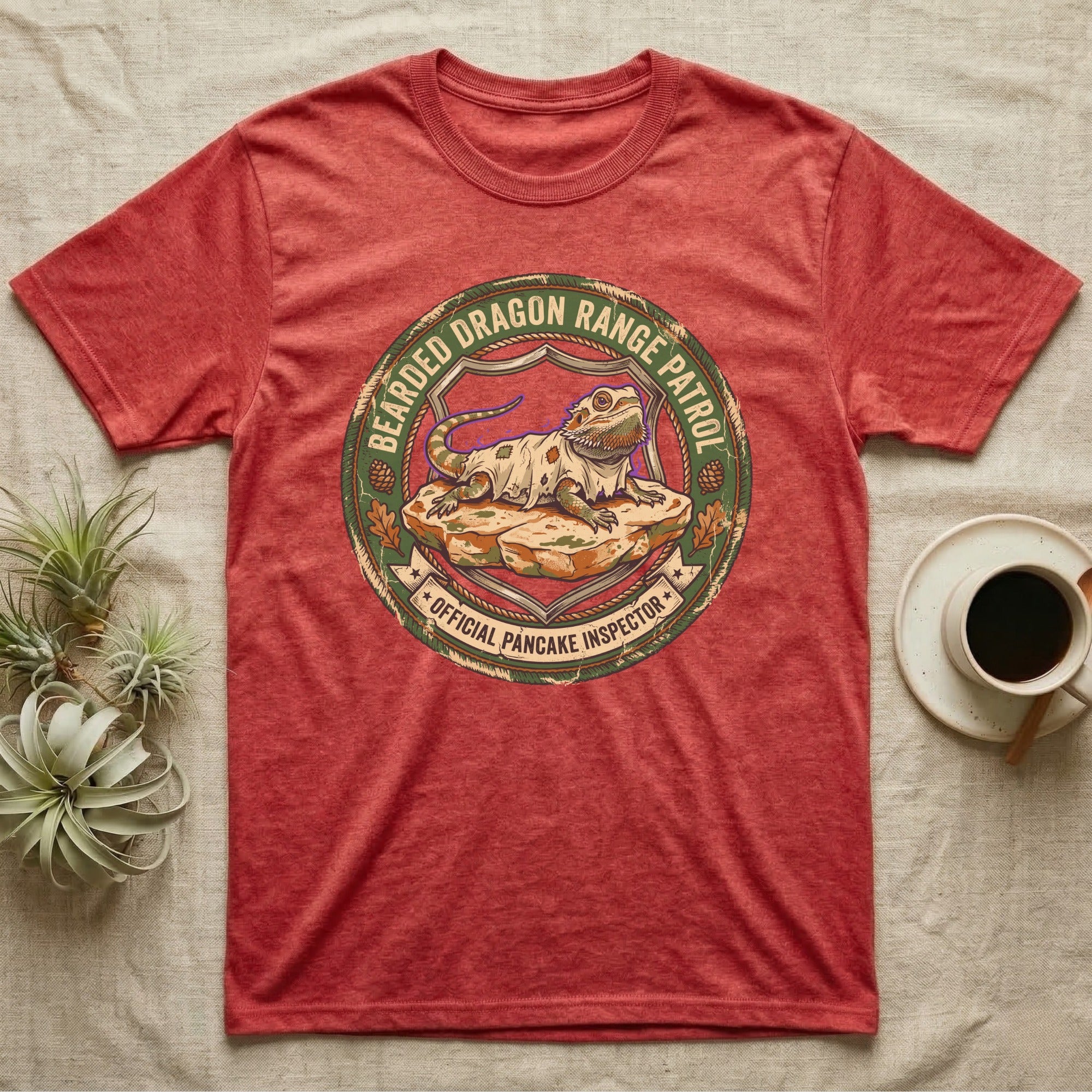 Bearded Dragon Pancake Inspector T-Shirt in Heather Red — Weathered ranger badge of a bearded dragon flattened on a rock, "Bearded Dragon Range Patrol, Official Pancake Inspector."