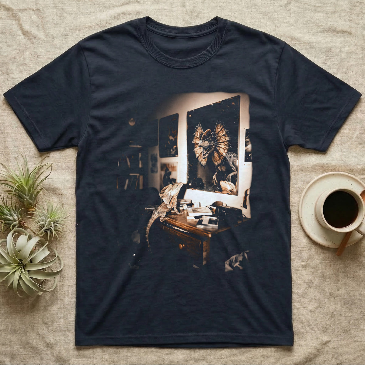 Frilled Lizard Dinosaur Mirror T-Shirt in Navy — Frilled lizard on a desk looking at a wall mirror reflecting a large frilled dinosaur with its frill flared.