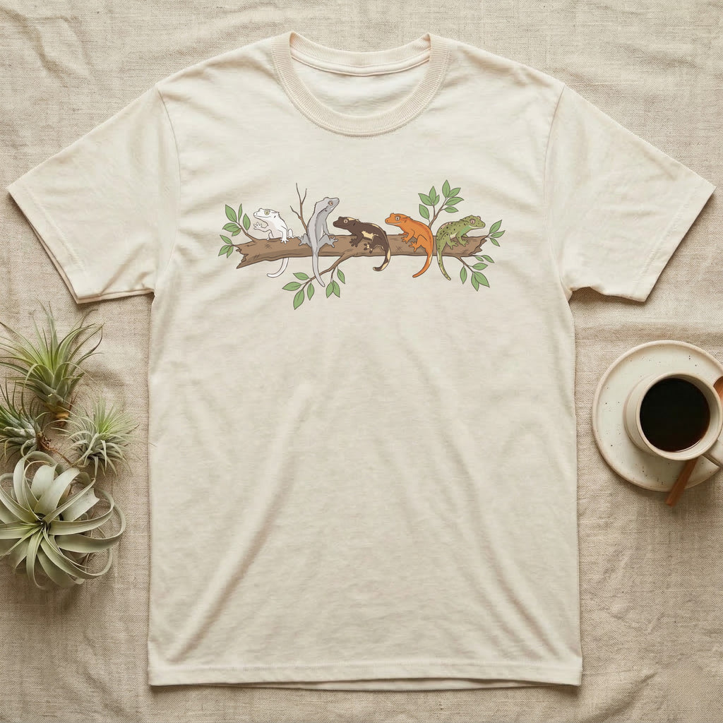 Crested Gecko Morph Line T-Shirt in Natural — Five crested gecko morphs in ink and watercolour perched along one cork bark branch with ficus leaves.