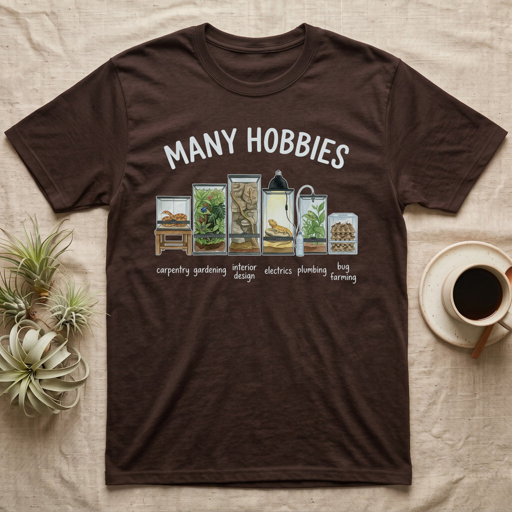 Reptile Terrarium Hobbies T-Shirt in Dark Chocolate — Watercolour row of reptile vivariums with a snake, dart frog, gecko, bearded dragon, tree frog and a cricket bin under MANY HOBBIES, each labelled carpentry to bug farming