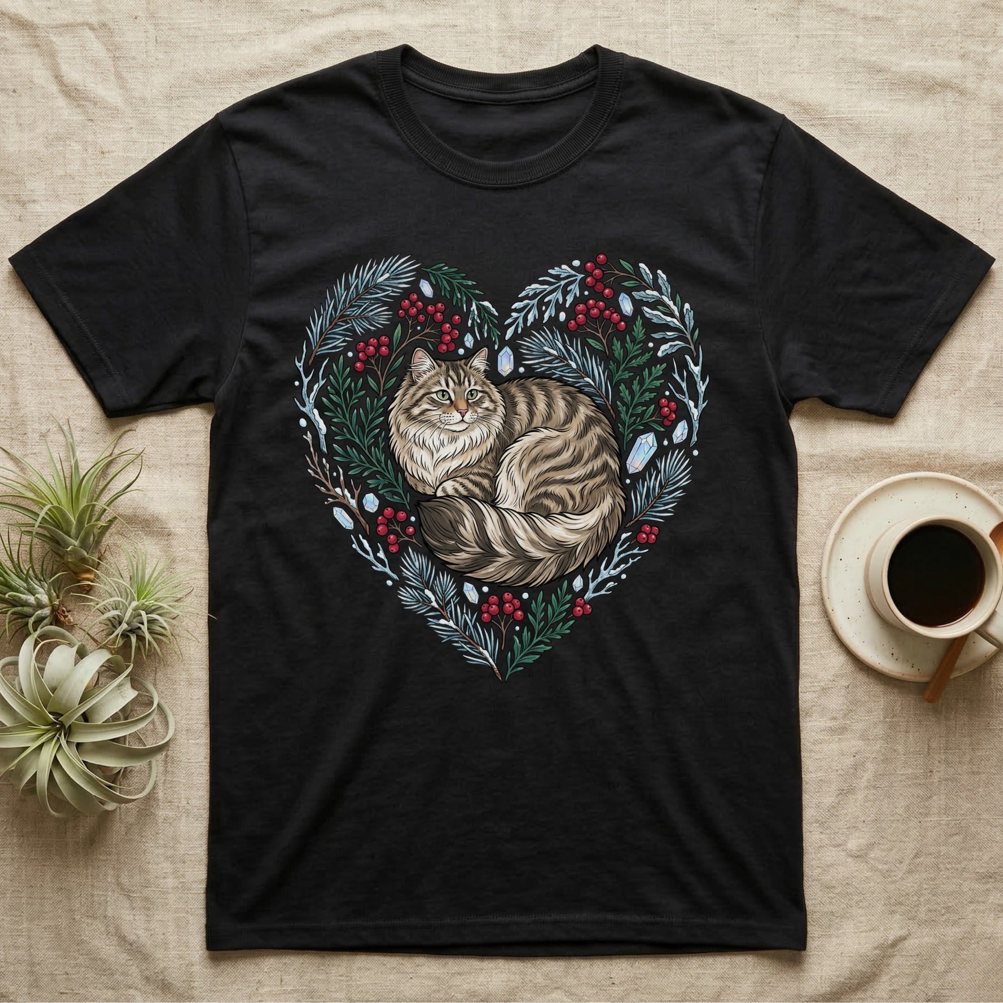 Black t-shirt with a heart-shaped design of a fluffy cat and winter foliage.