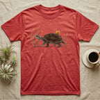 Musk Turtle Hitchhiker T-Shirt in Heather Red — Watercolour musk turtle walking left with a ramshorn snail on its shell, beside slender grass blades with tiny amber flowers.