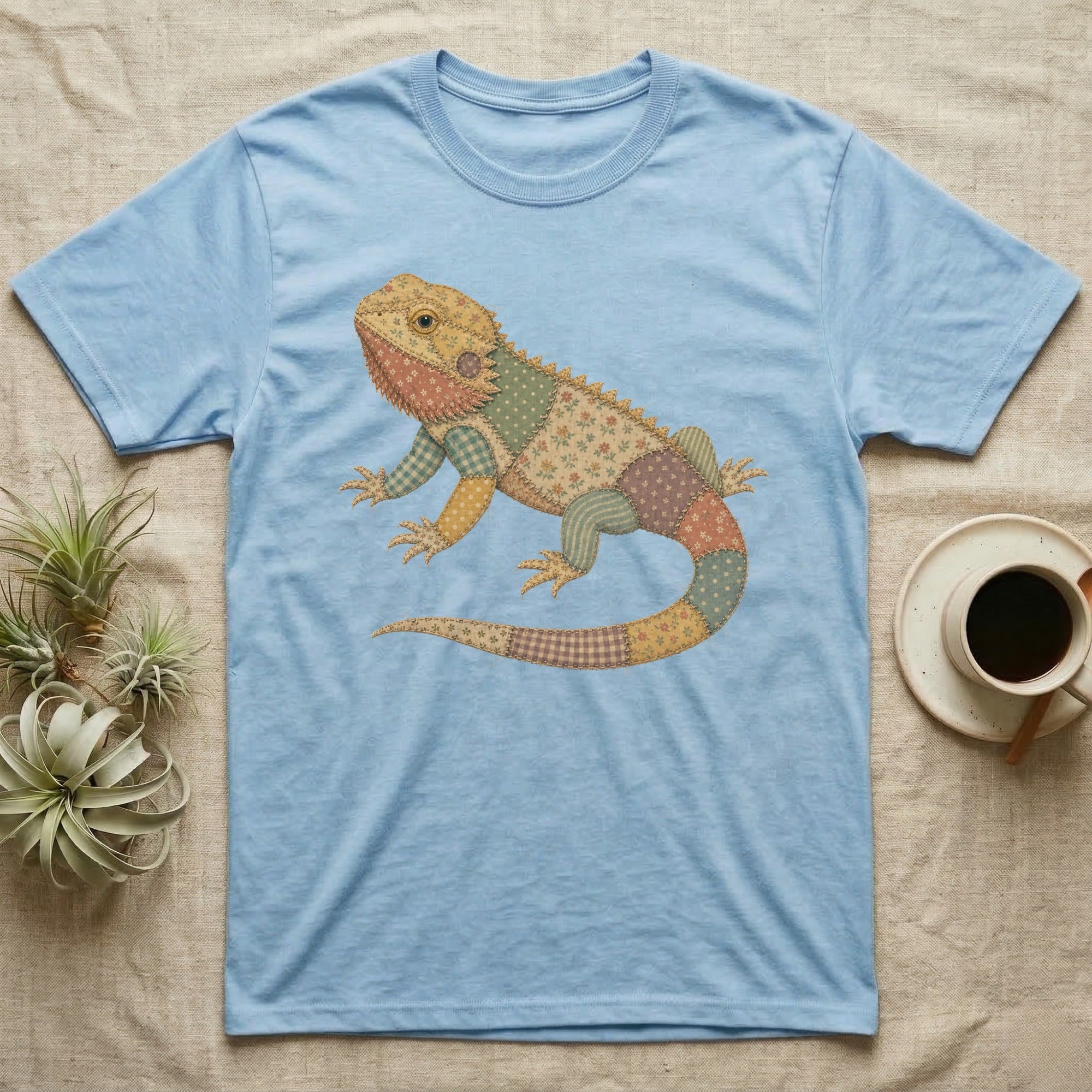 Light blue t-shirt with a colorful, patchwork bearded dragon graphic.