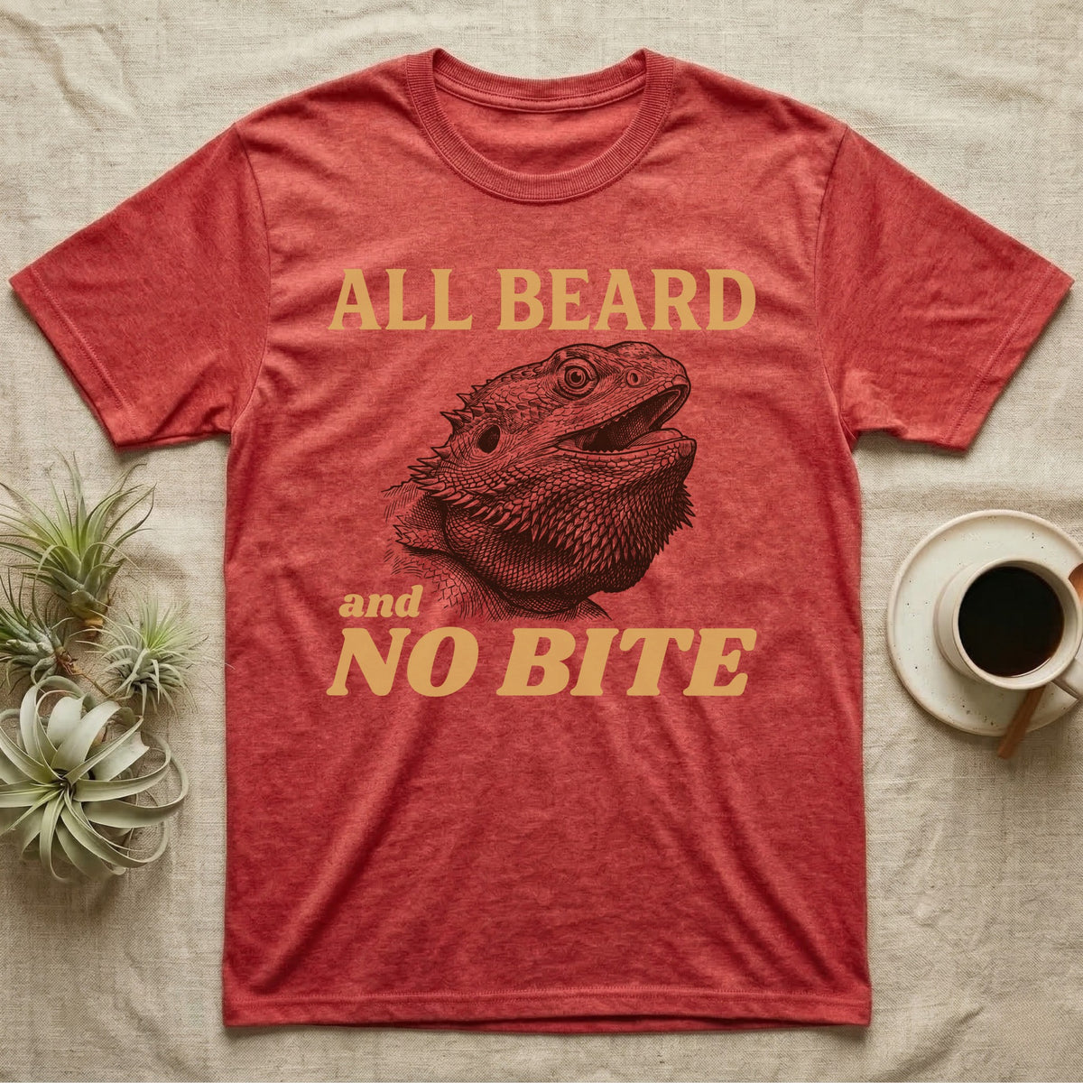Bearded Dragon Bluff T-Shirt in Heather Red — Engraved bearded dragon with a puffed dark beard and open mouth under sand lettering reading ALL BEARD and NO BITE