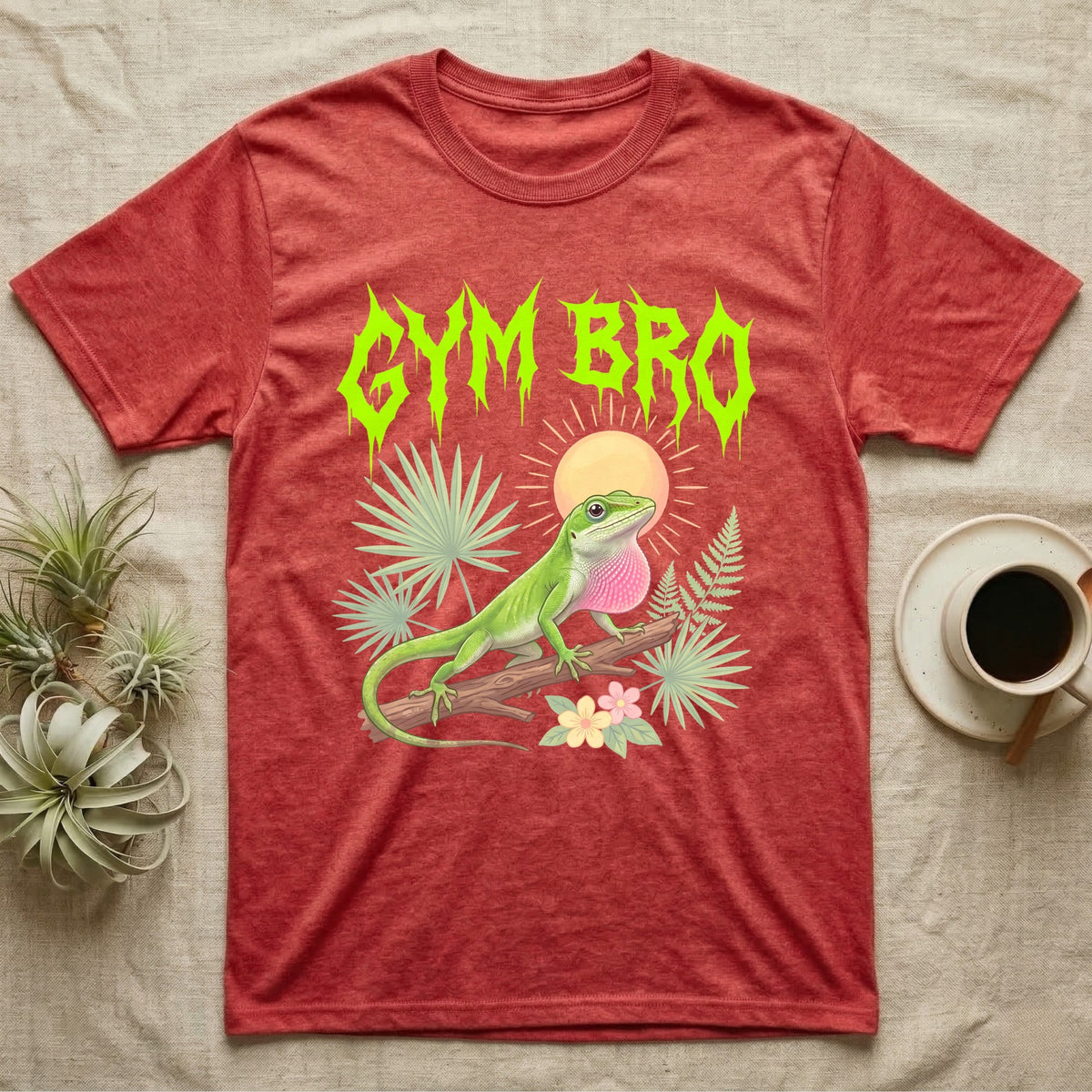 Green Anole Feral T-Shirt in Heather Red — Green anole mid push-up with flared pink dewlap under a jagged neon-lime metal "GYM BRO" wordmark and pastel ferns.