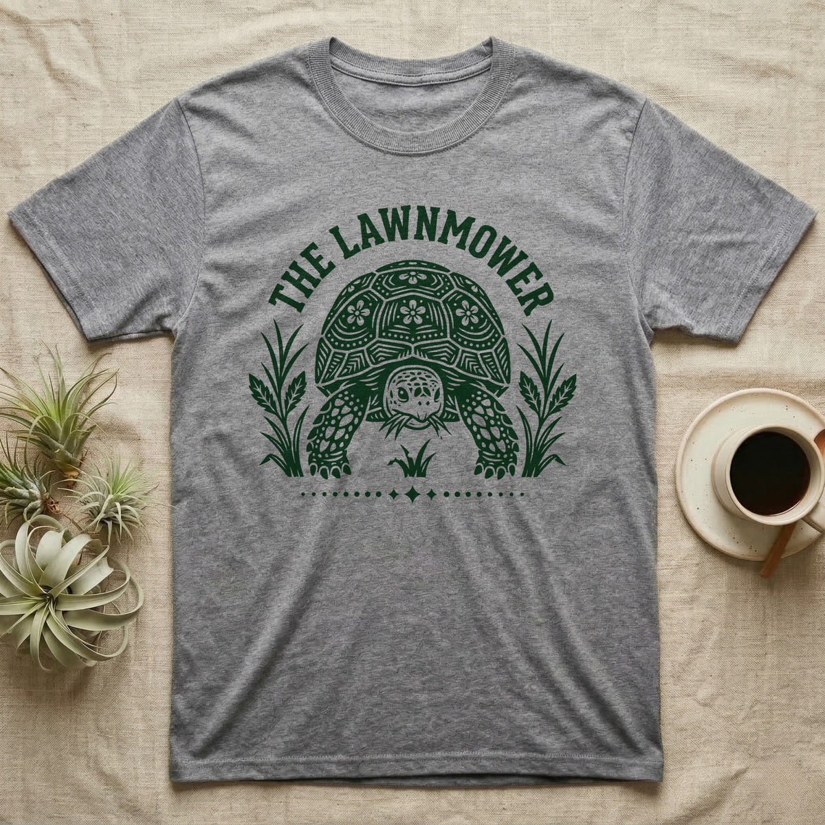 Sulcata Tortoise Under Lawn T-Shirt in Sport Grey — Engraved sulcata tortoise in white line, head down and legs braced mid-dig, under retro script reading UNDER THE LAWN.