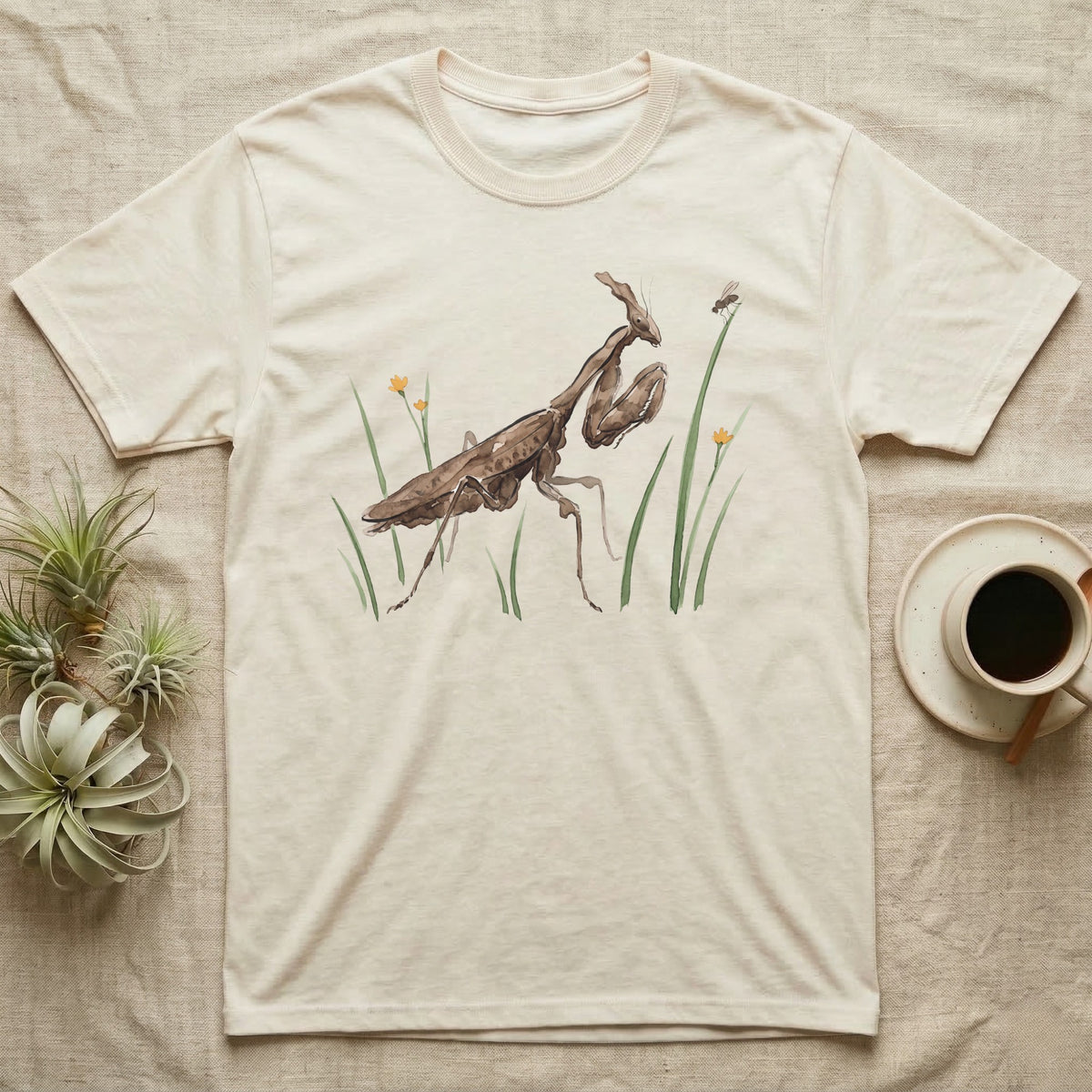 Ghost Mantis Watercolour T-Shirt in Natural — Watercolour ghost mantis standing still in profile with forelegs folded, watching a single fruit fly perched on a grass tip.