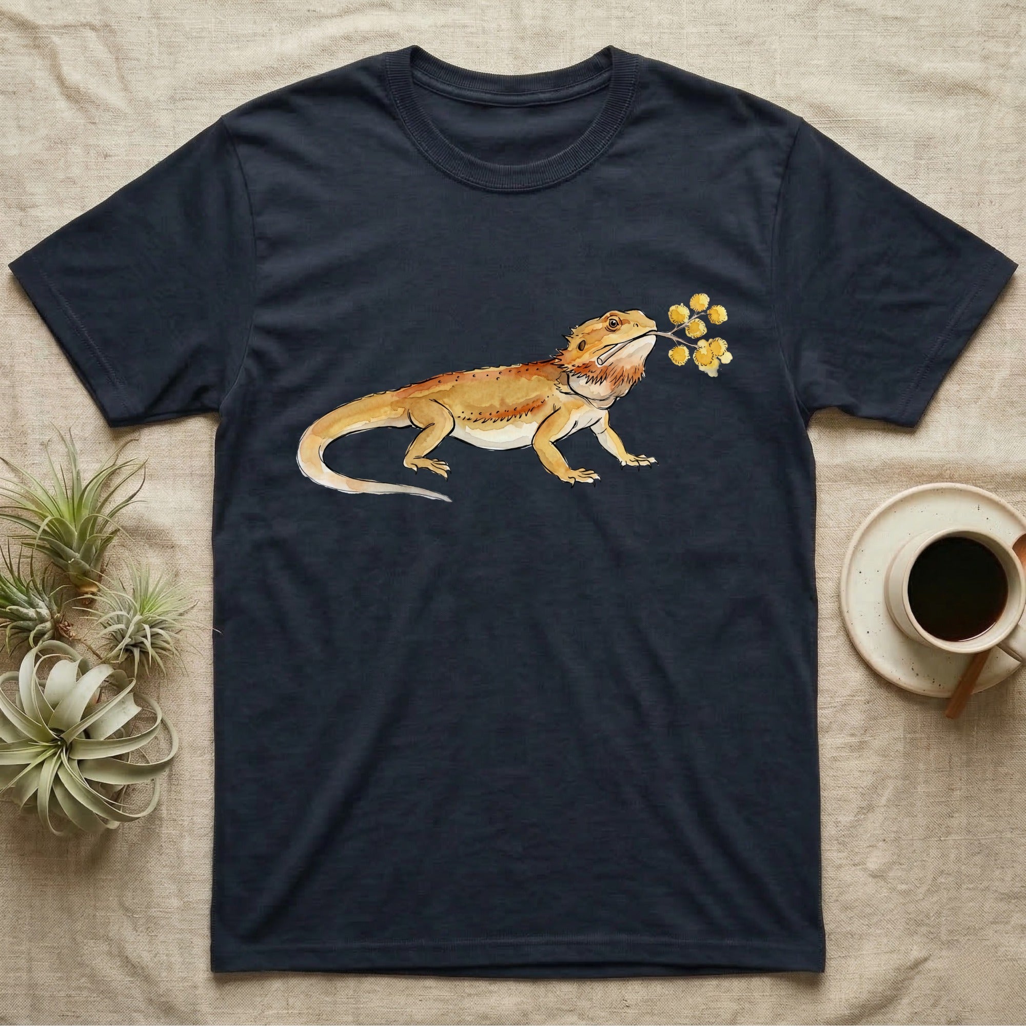 Bearded Dragon Blossom T-Shirt in Navy — Watercolor illustration of an ochre bearded dragon holding a golden wattle blossom sprig, on a dark grey t-shirt.
