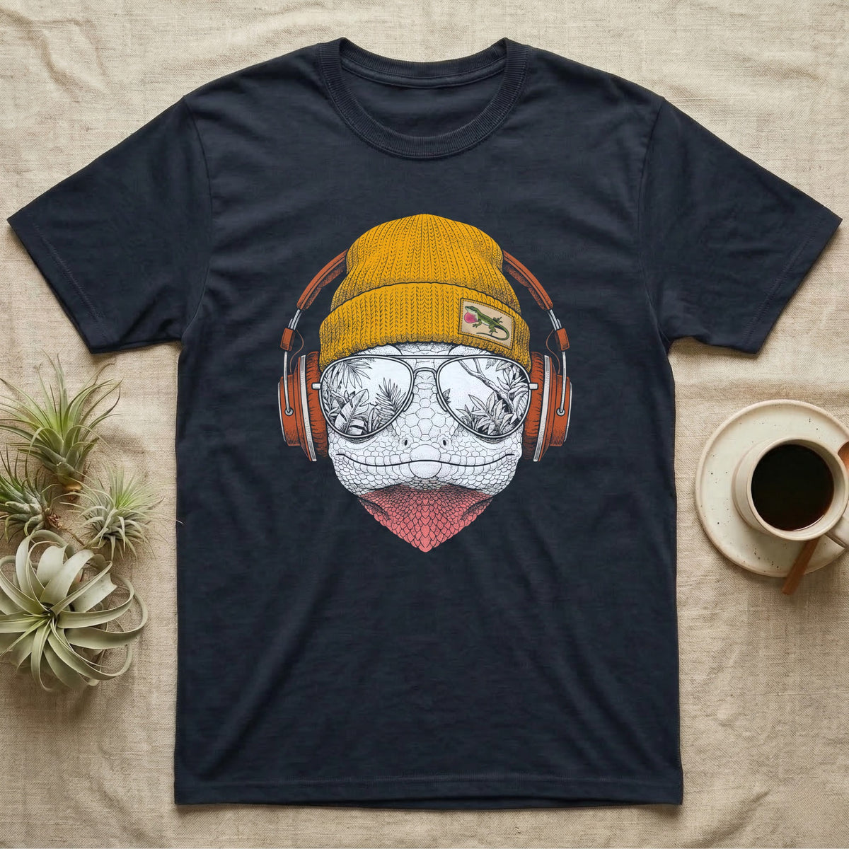 Green Anole Chill Beats T-Shirt in Navy — Engraved green anole with pink dewlap showing, in a beanie and headphones, aviators reflecting tropical palms.