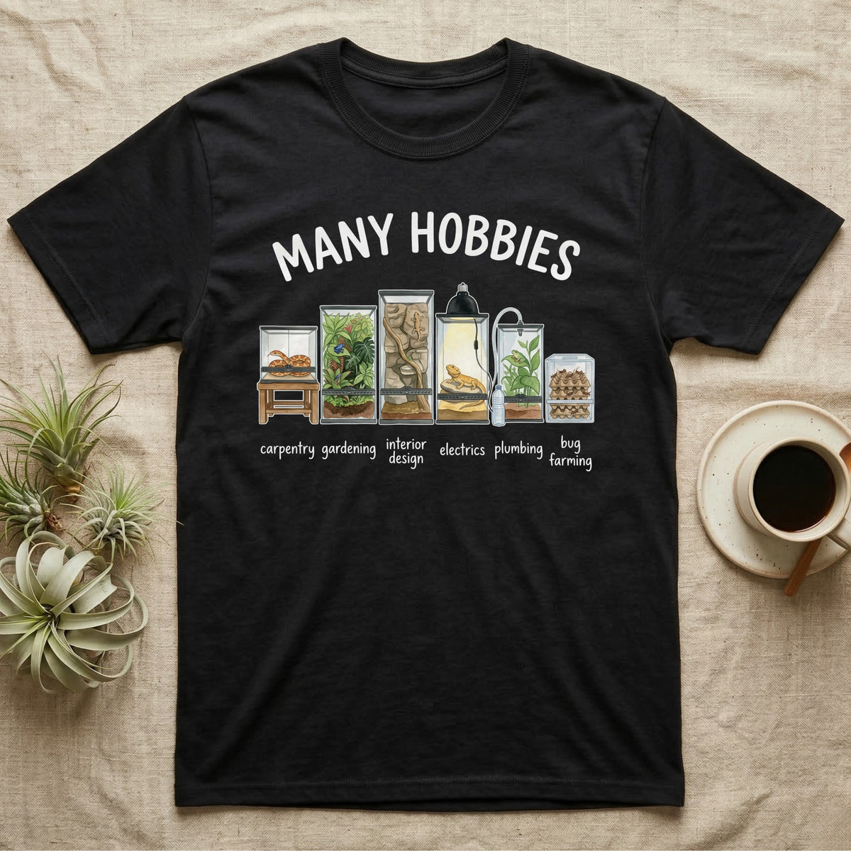 Reptile Terrarium Hobbies T-Shirt in Black — Watercolour row of reptile vivariums with a snake, dart frog, gecko, bearded dragon, tree frog and a cricket bin under MANY HOBBIES, each labelled carpentry to bug farming