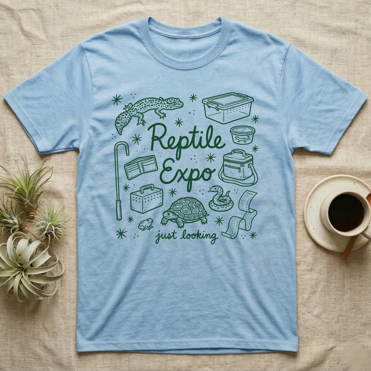 Reptile Expo T-Shirt in Light Blue — Green marker cursive reading Reptile Expo just looking, ringed by doodles of deli cups, tubs, a gecko and a tortoise
