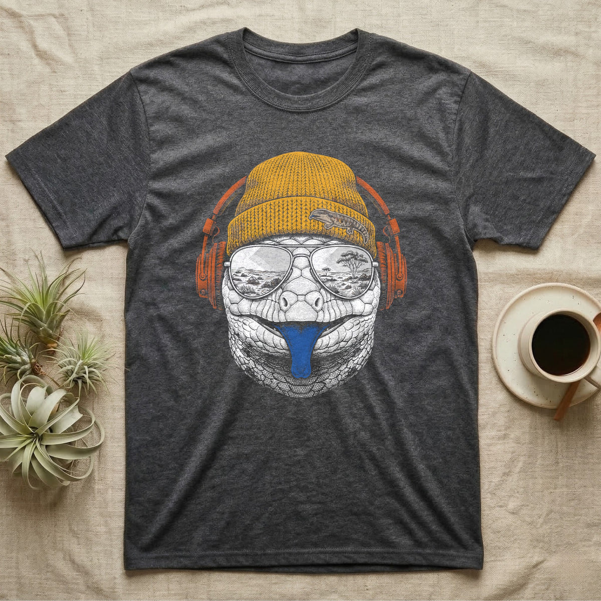 Blue-Tongued Skink Headphones T-Shirt in Dark Heather — Engraved blue-tongued skink with cobalt tongue out, wearing a beanie and headphones, aviators reflecting the outback.