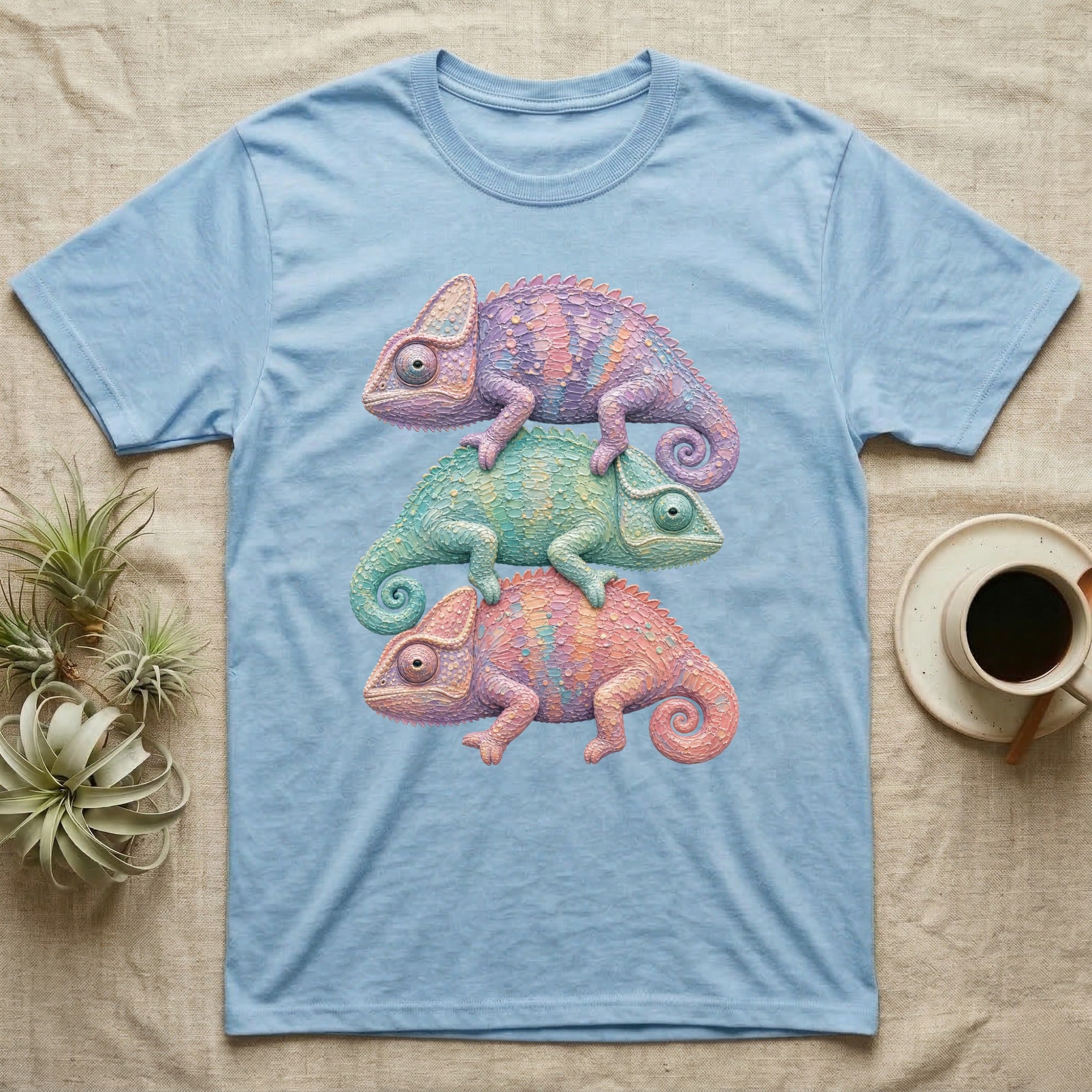 Three colorful chameleons stacked on a light blue t-shirt.