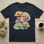 Three pastel-colored geckos stacked on a dark t-shirt.