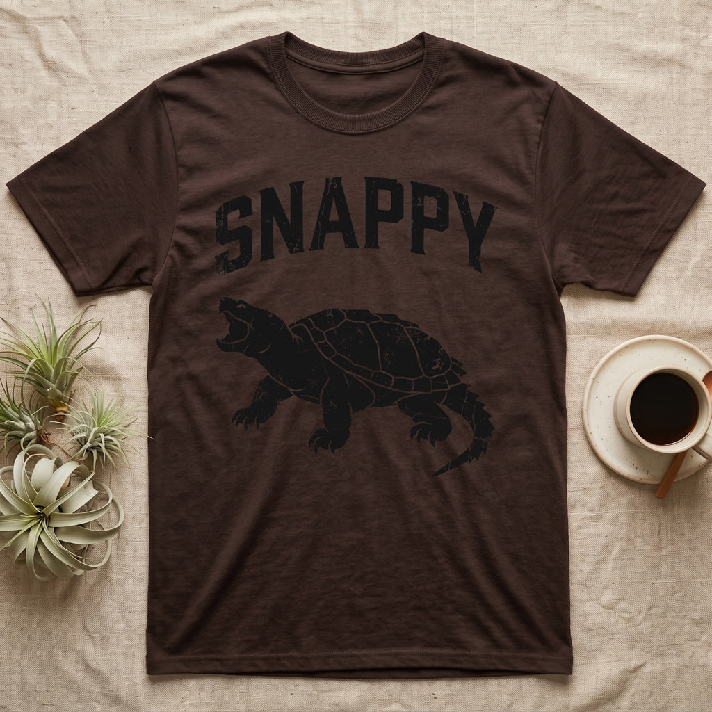Snapping Turtle Snappy T-Shirt in Dark Chocolate — Worn one-ink print of a common snapping turtle crouched side-on, jaws open mid-snap, under the arched word SNAPPY