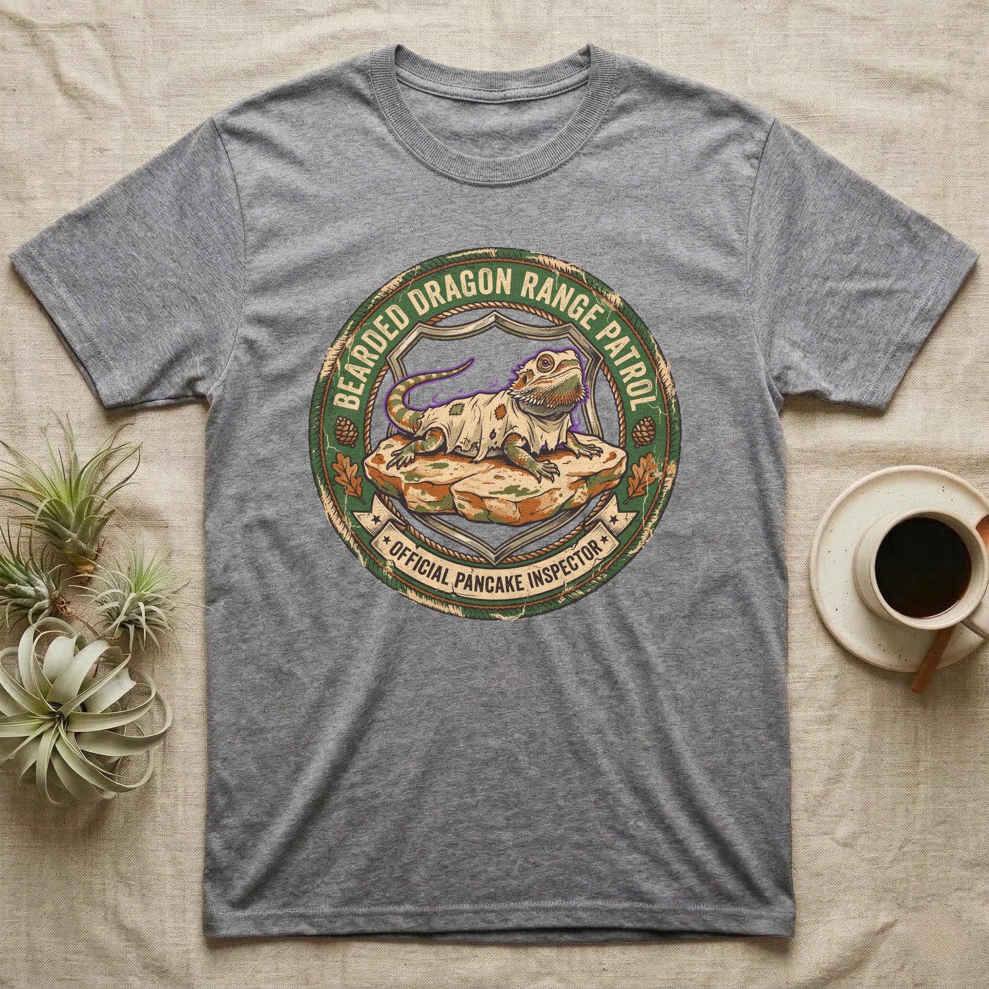 Bearded Dragon Pancake Inspector T-Shirt in Sport Grey — Weathered ranger badge of a bearded dragon flattened on a rock, "Bearded Dragon Range Patrol, Official Pancake Inspector."