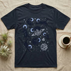 Dark t-shirt with illustrations of black cats floating in space with planets and stars.