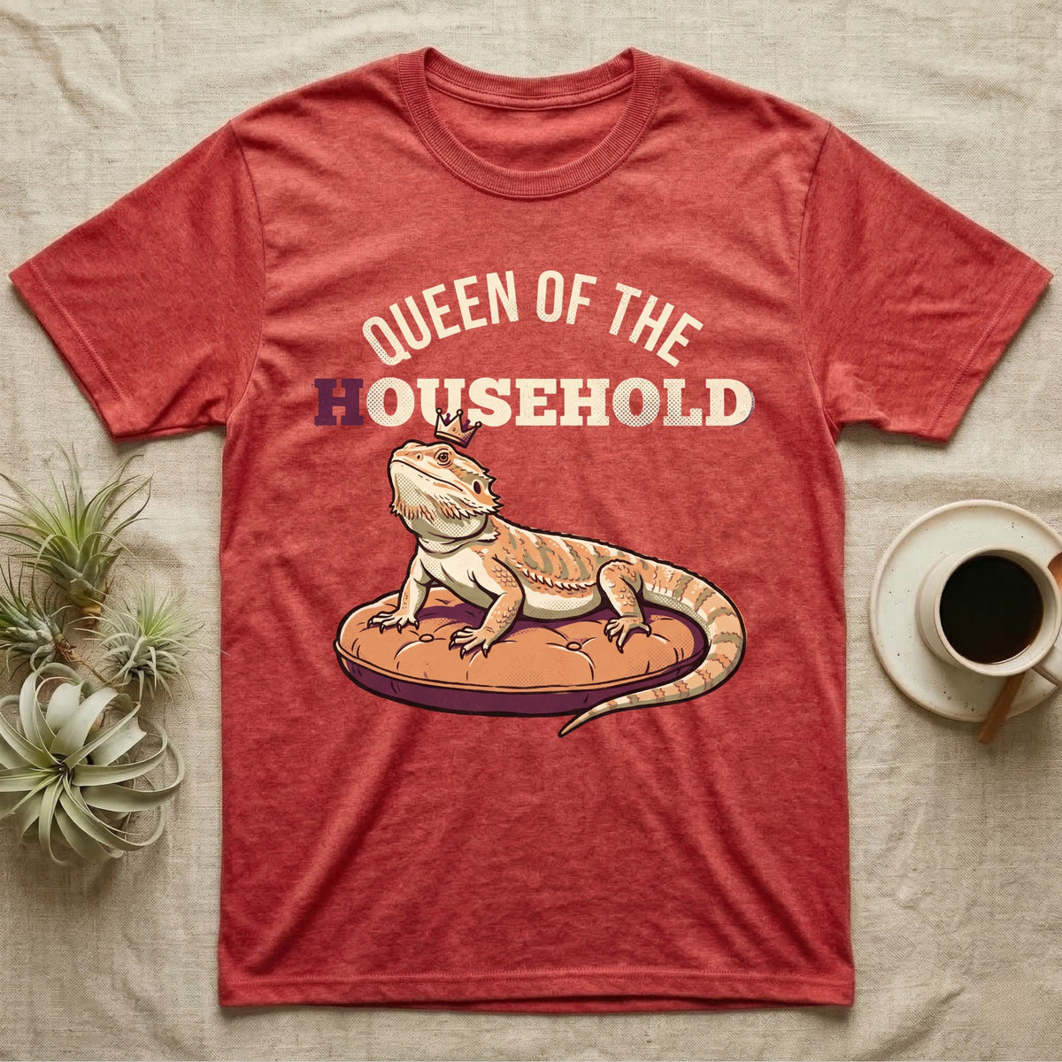 Queen Bearded Dragon T-Shirt in Heather Red — Bold-vector illustration of a bearded dragon on a throne-cushion with a crown under varsity Queen of the Household lettering.