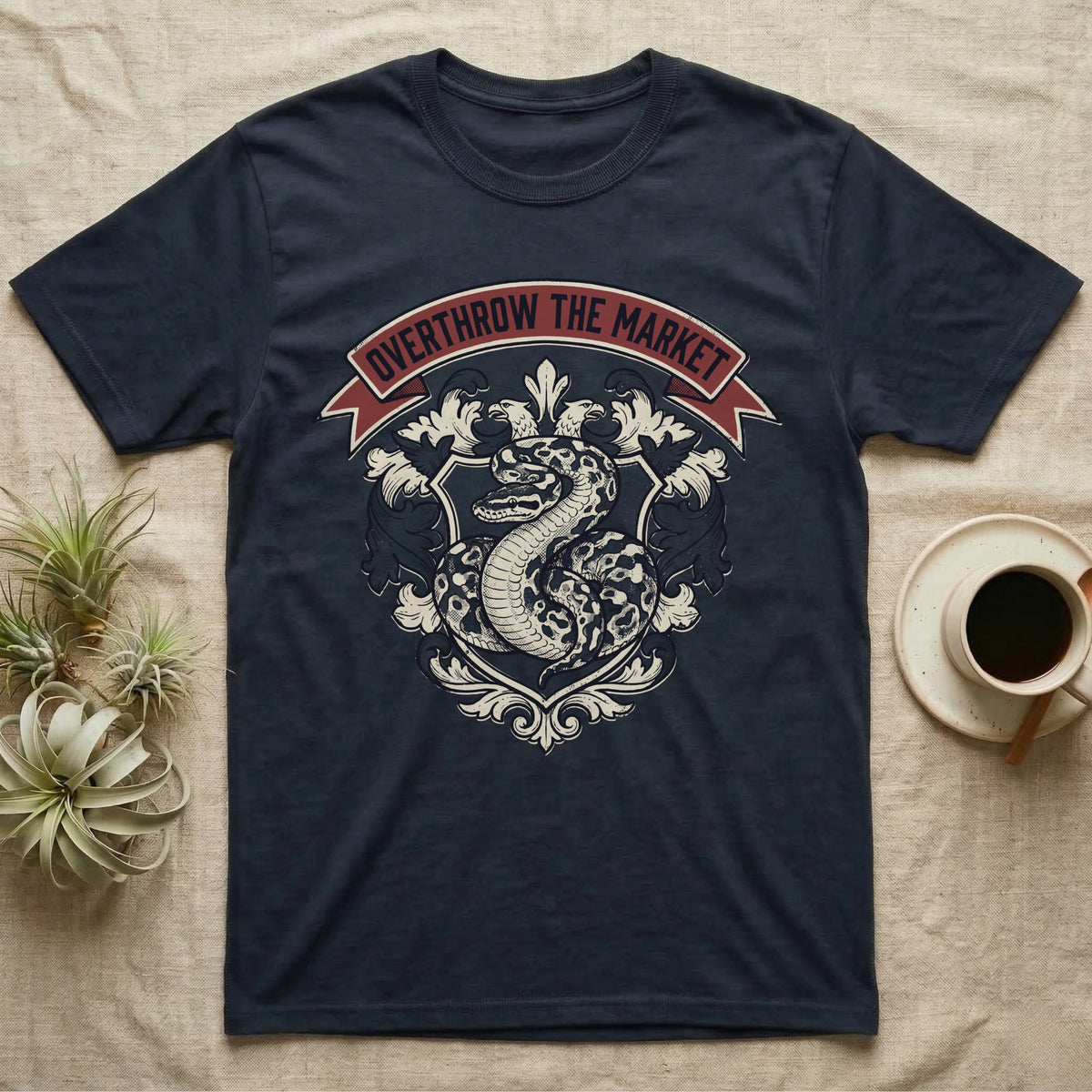 Overthrow The Market Python T-Shirt in Navy — Vintage heraldic-crest illustration of a regal ball python with a banner reading "Overthrow The Market."