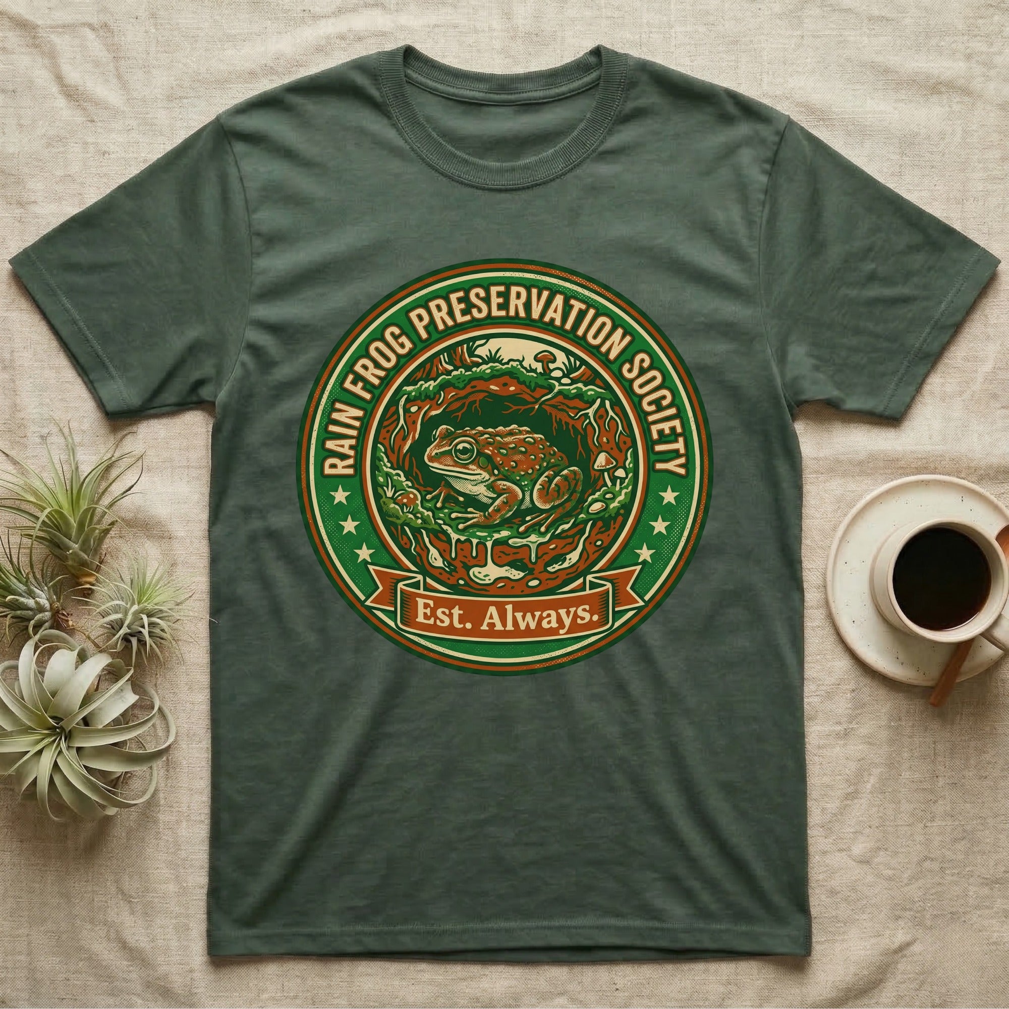 Green t-shirt with circular "Rain Frog Preservation Society Est. Always" logo.