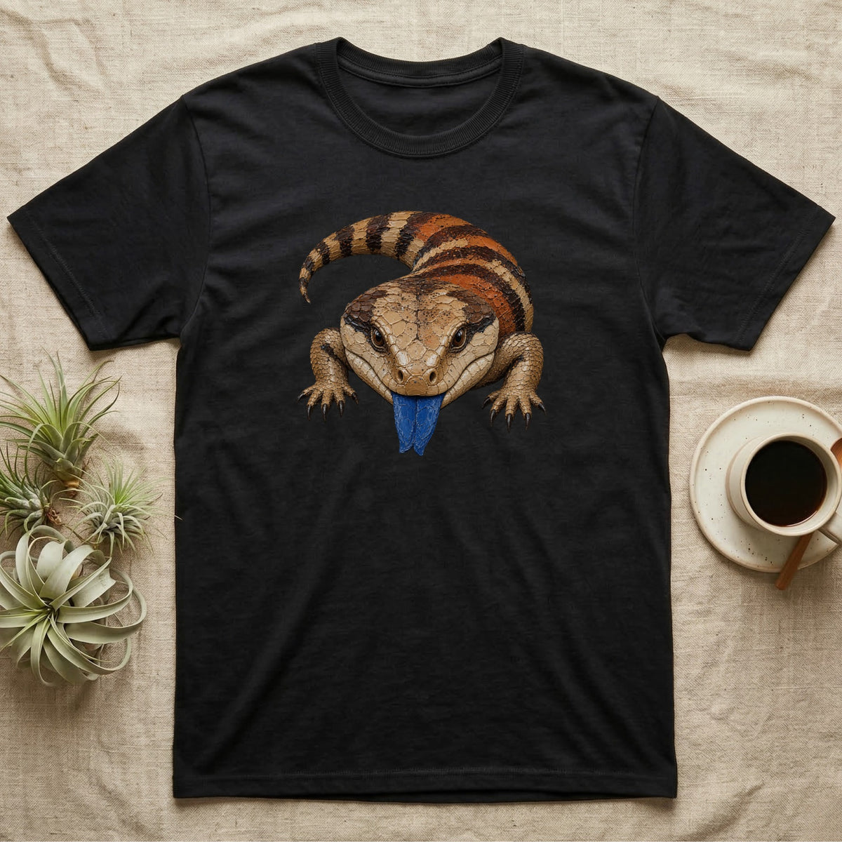 Black t-shirt with illustration of a blue-tongued skink with its tongue out.