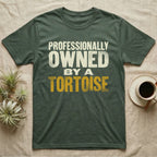 Owned By A Tortoise T-Shirt in Military Green — Distressed woodtype wordmark reading professionally owned by a tortoise in a bold two-tier lockup, text only.