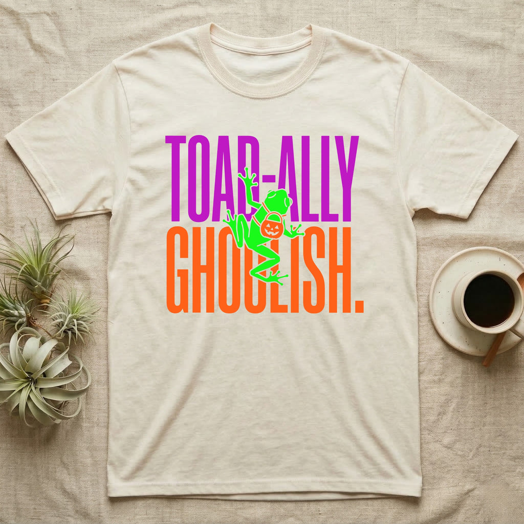 Tree Frog Toad-ally Ghoulish T-Shirt in Natural — Neon green tree frog with a pumpkin pail clinging across stacked text, "Toad-ally Ghoulish."