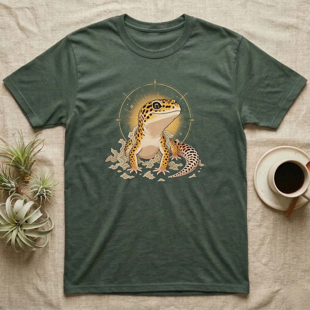 Leopard Gecko Shed T-Shirt in Military Green — Bold vector illustration of a leopard gecko emerging fresh from a shed, lit by a soft warm halo glow.