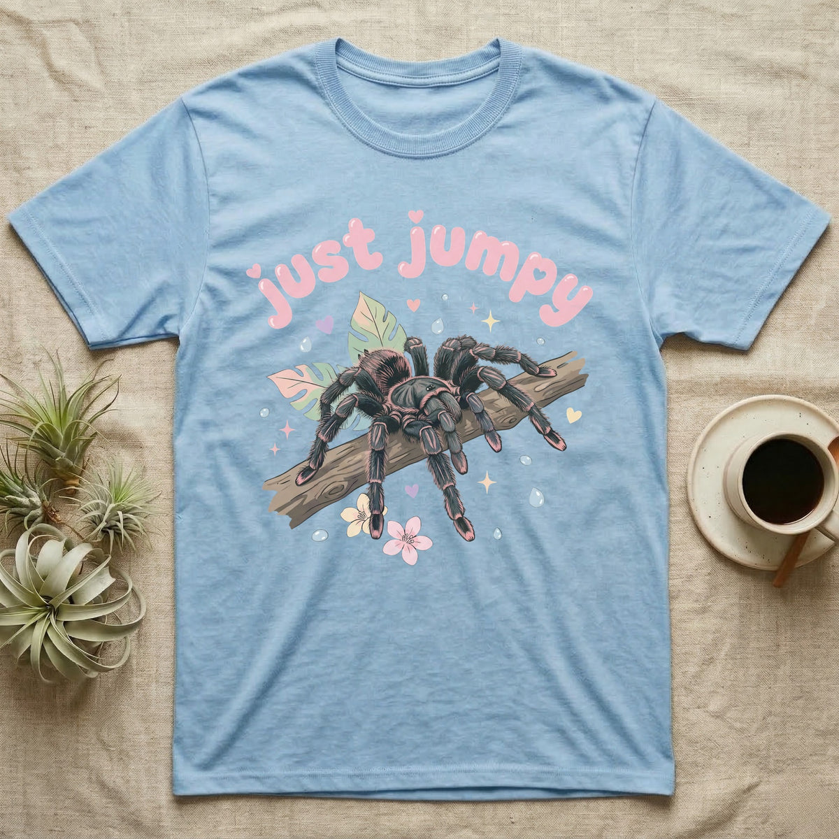 Pink Toe Tarantula Softie T-Shirt in Light Blue — Pink toe tarantula poised to leap on a branch under a puffy pastel "just jumpy" bubble wordmark with tiny hearts.