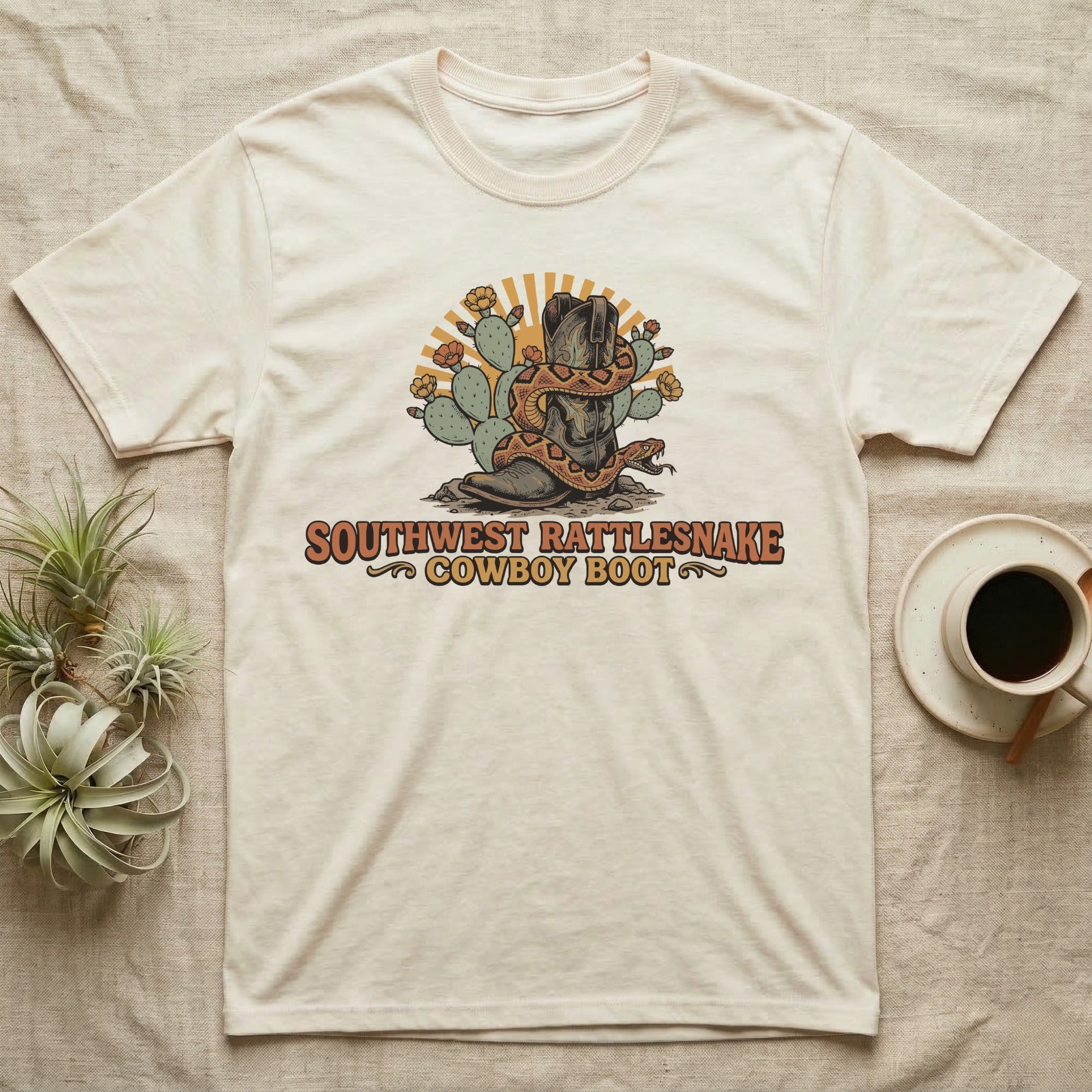 T-shirt with cowboy boot, snake, cacti, and sun graphic.