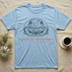 Dumpy Tree Frog T-Shirt in Light Blue — Engraved White's tree frog sitting square-on in a flat, tucked loaf pose under large retro lettering reading DUMPY, THRIVING, and I know it.