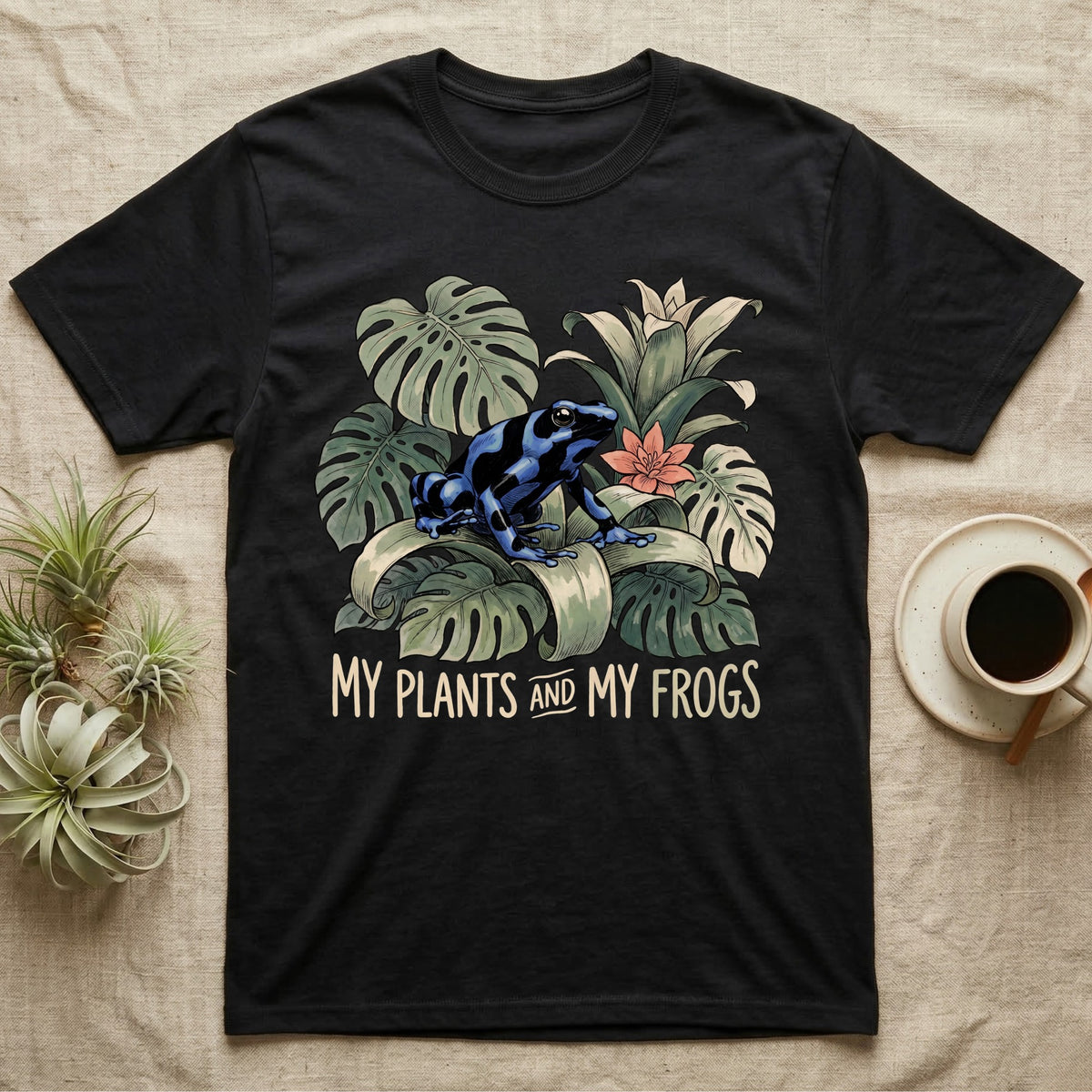 Plants And Frogs T-Shirt in Black — Naturalist-plate illustration of a dart frog perched in lush foliage with hand-lettered text reading My Plants And My Frogs.