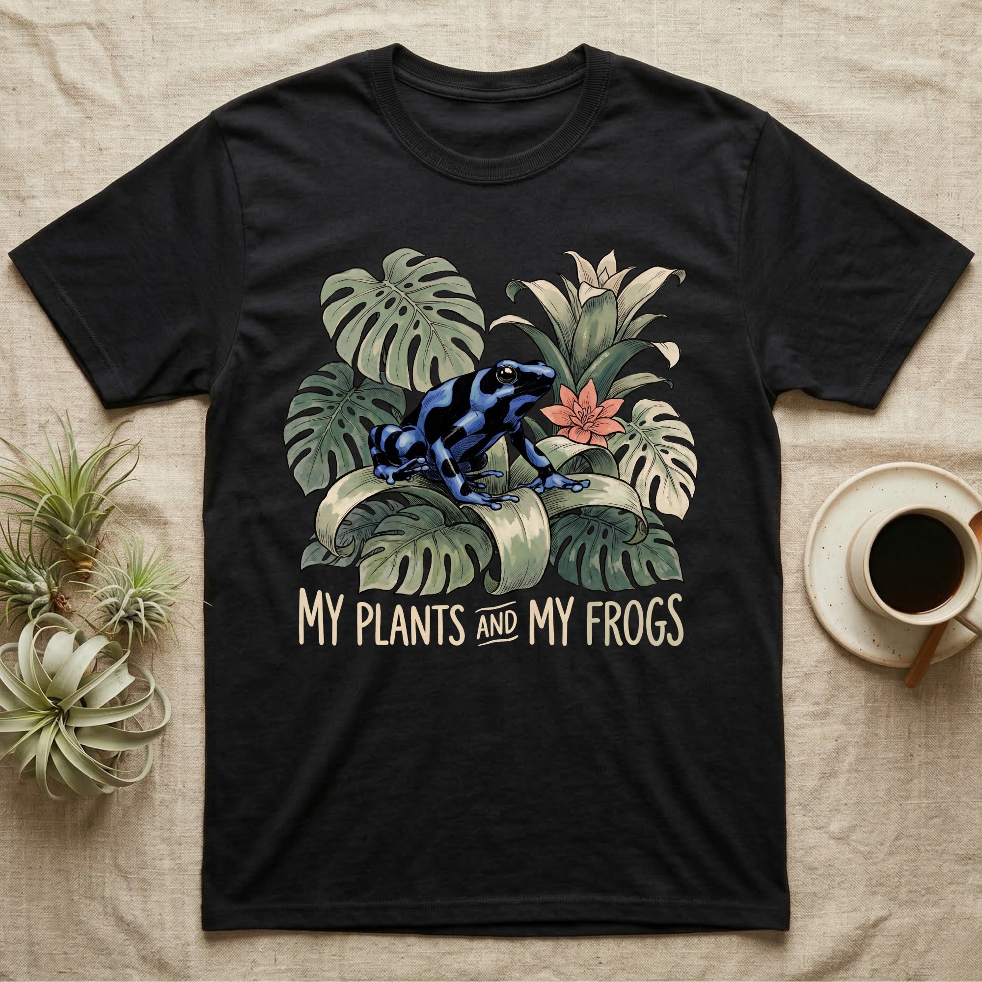 Plants And Frogs T-Shirt in Black — Naturalist-plate illustration of a dart frog perched in lush foliage with hand-lettered text reading My Plants And My Frogs.