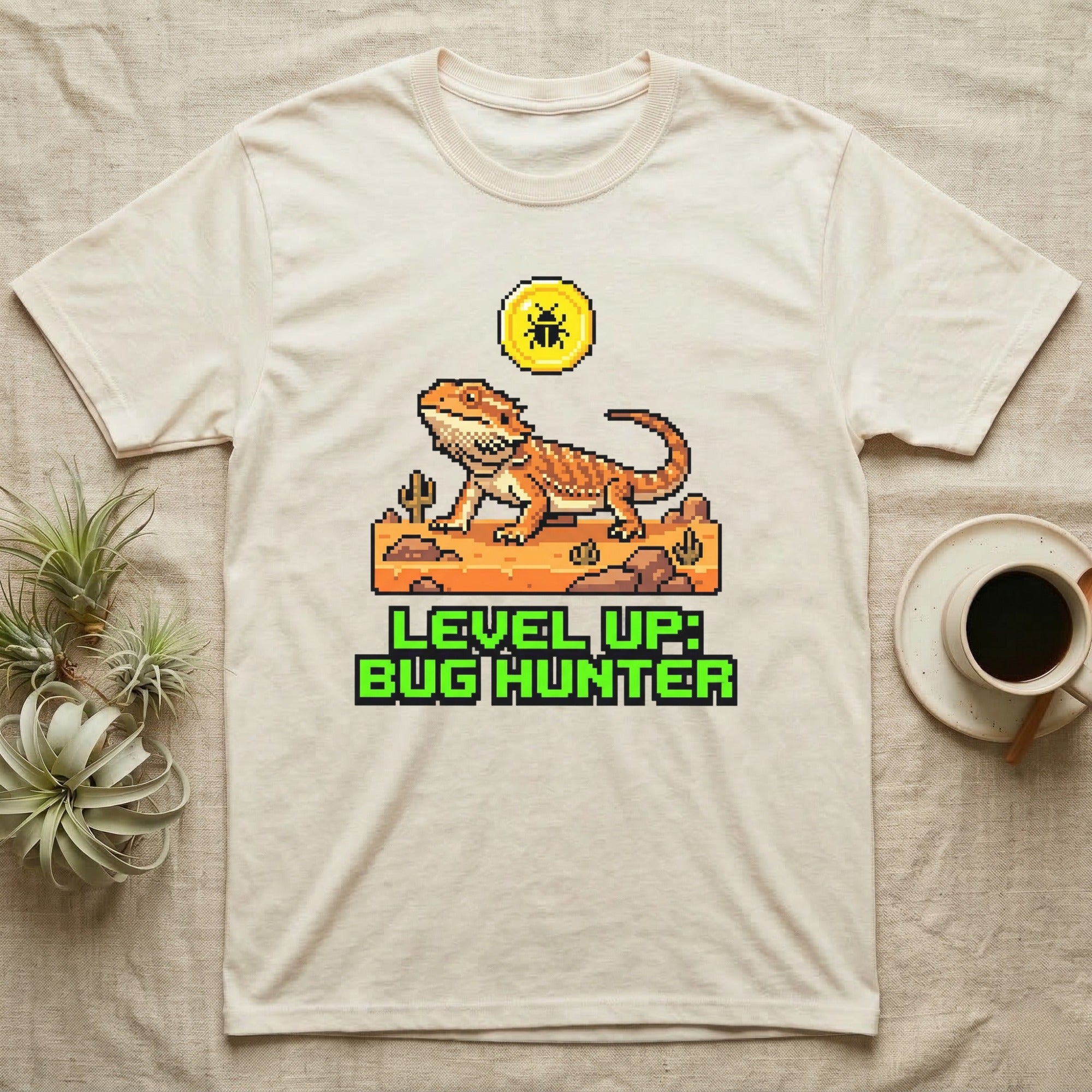 Cream t-shirt with pixel art of a bearded dragon and text "LEVEL UP: BUG HUNTER".