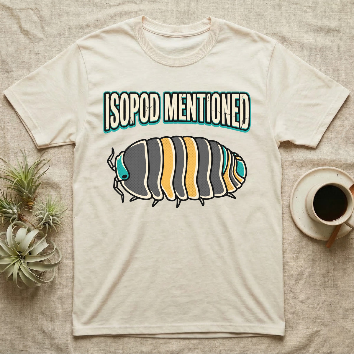 Isopod Mentioned T-Shirt in Natural — Bold-vector illustration of a rubber-ducky Cubaris isopod hero under big block caps reading Isopod Mentioned.
